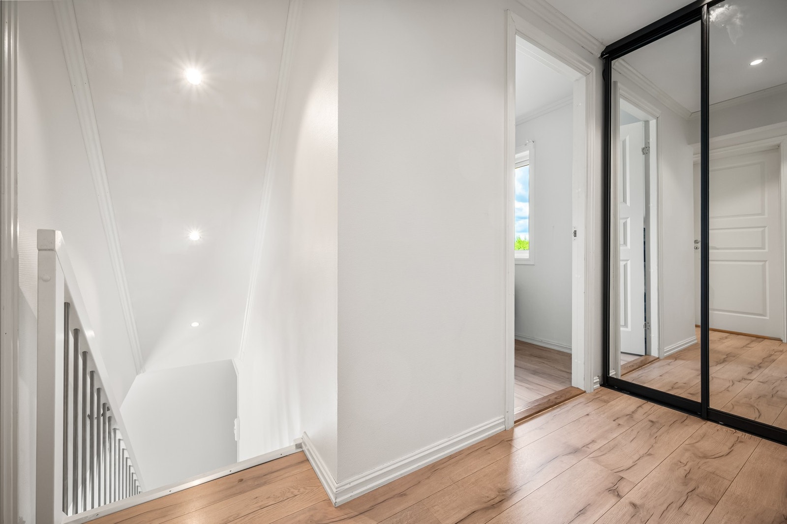 Trapperommet oppleves lyst og ryddig med moderne overflater og god oppbevaringsplass i praktisk skyvedørsgarderobe med speildører. Galleribilde