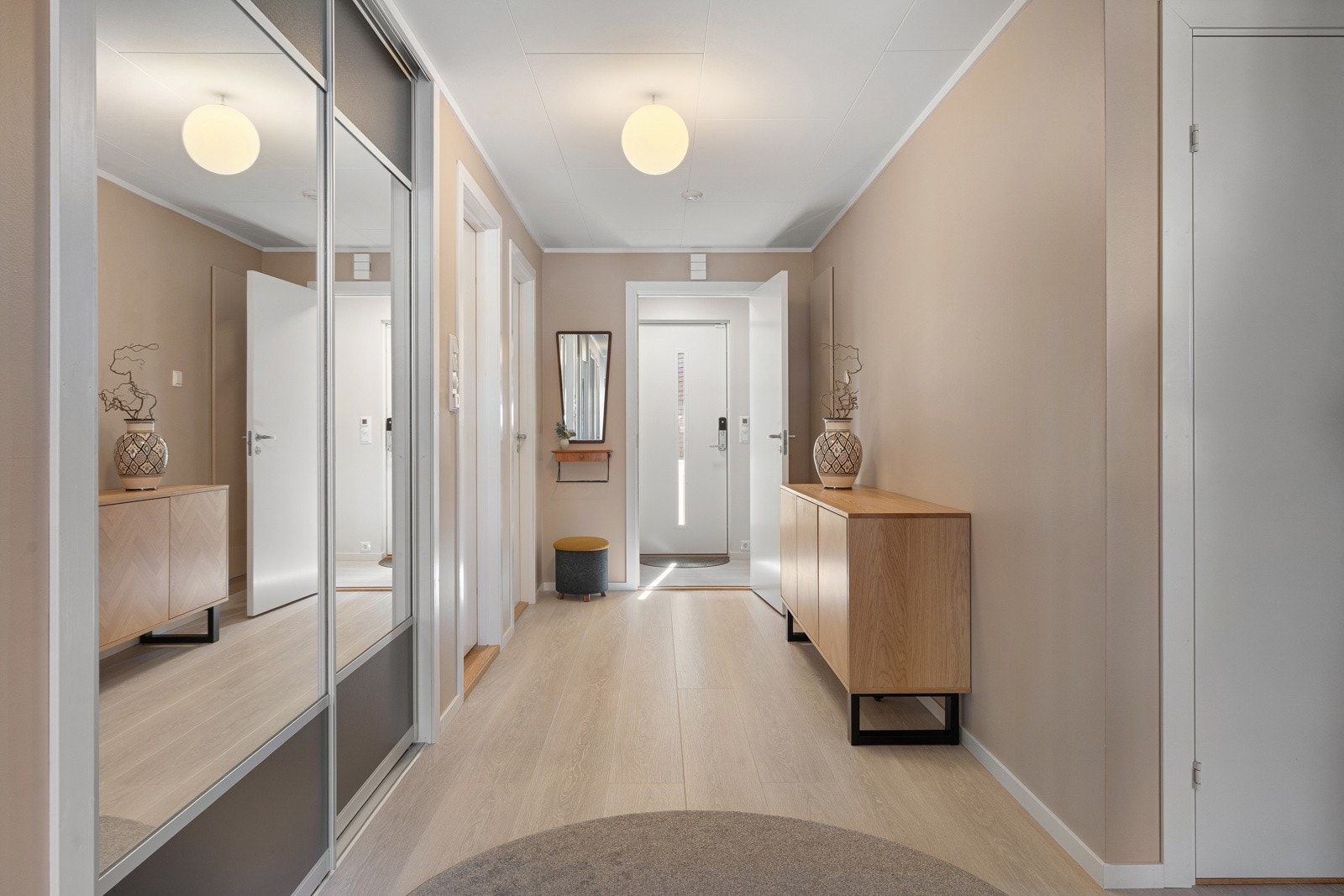 Lys og trivelig entré med romslig skyvedørsgarderobe og helfigurspeil. Galleribilde