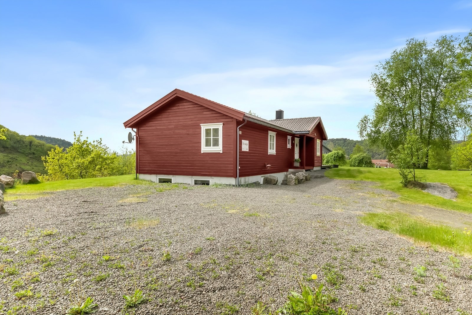 Stort gruslagt gårdsrom med god plass til parkering. Galleribilde