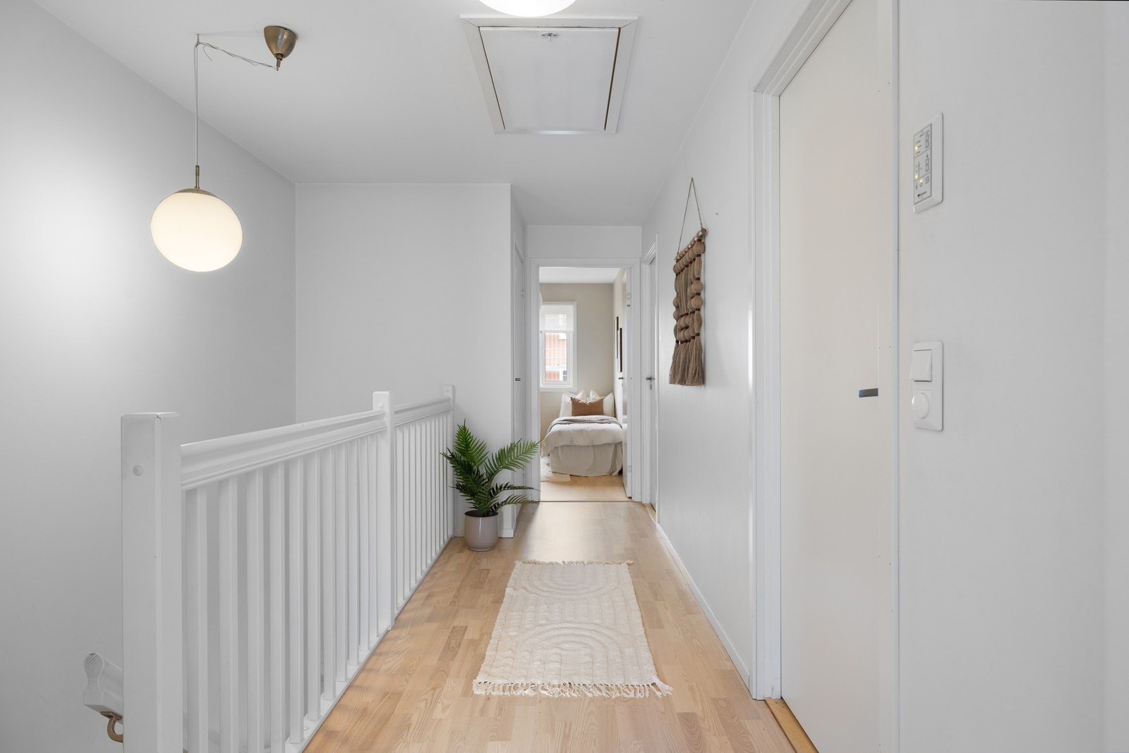 Luftig gang i 2.etasje. Hovedsoverommet ligger en én ende av etasjen, et bad ligger til høyre i bildet, samt at de to resterende soverommene ligger i motsatt ende av etasjen. Galleribilde