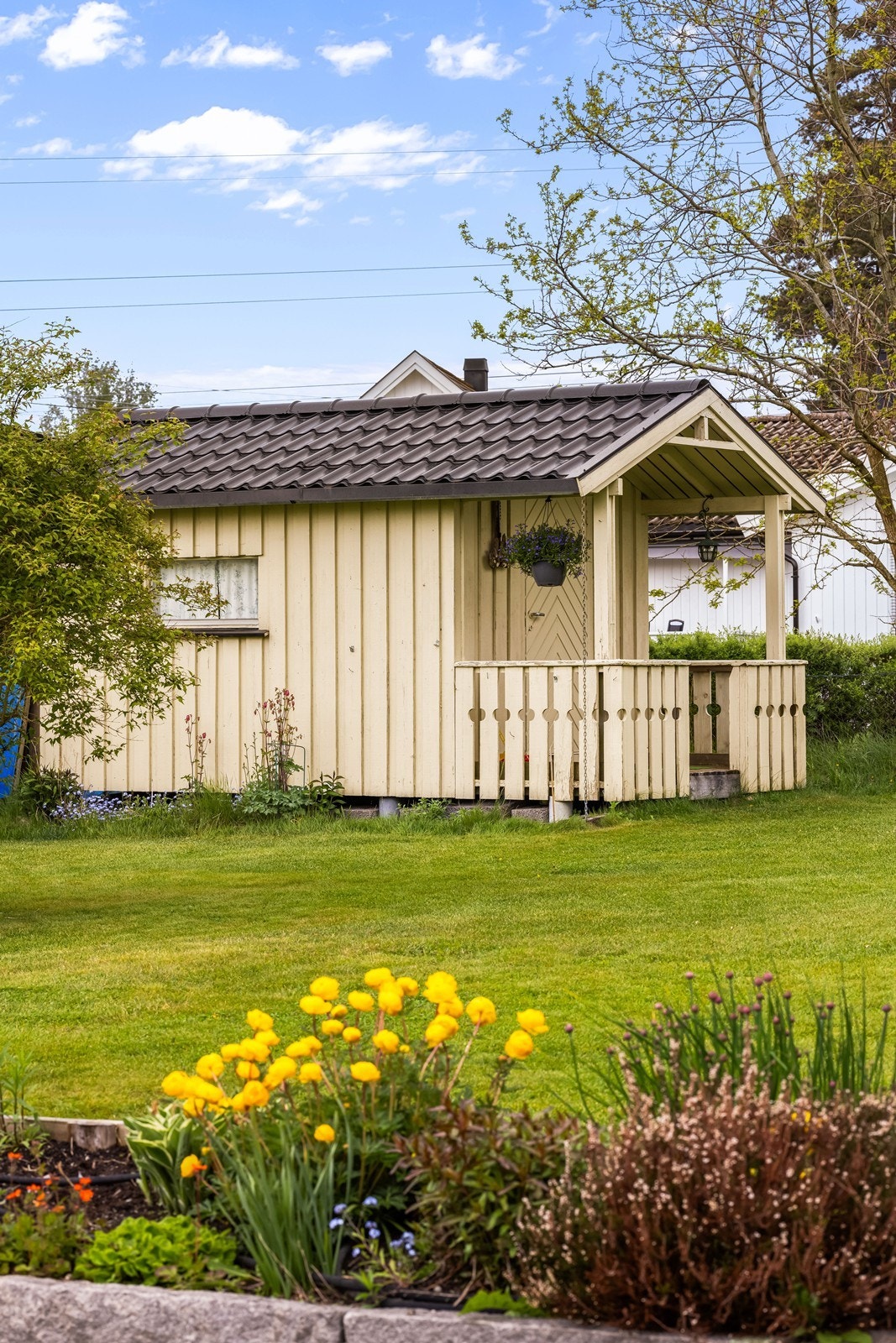 Frittstående lekestue i trekonstruksjon, utvendig kledd med malt trepanel. Galleribilde