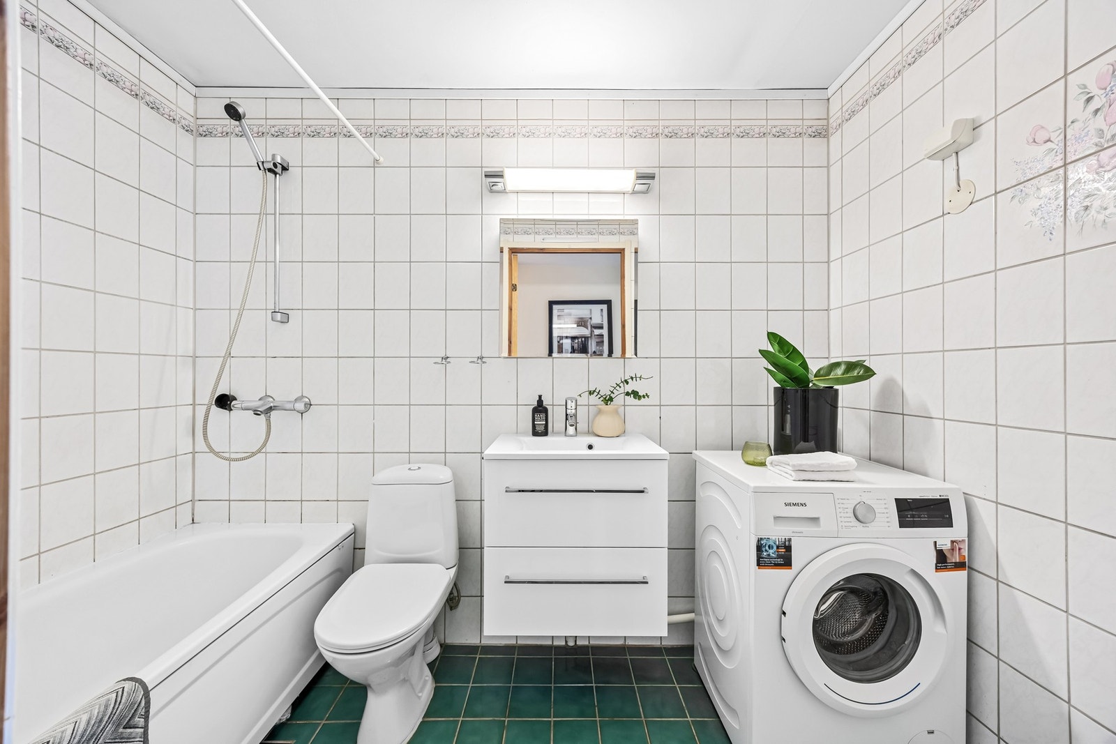 Flislagt bad/wc med varmekabler og praktisk innredning med servant og speilskap Galleribilde