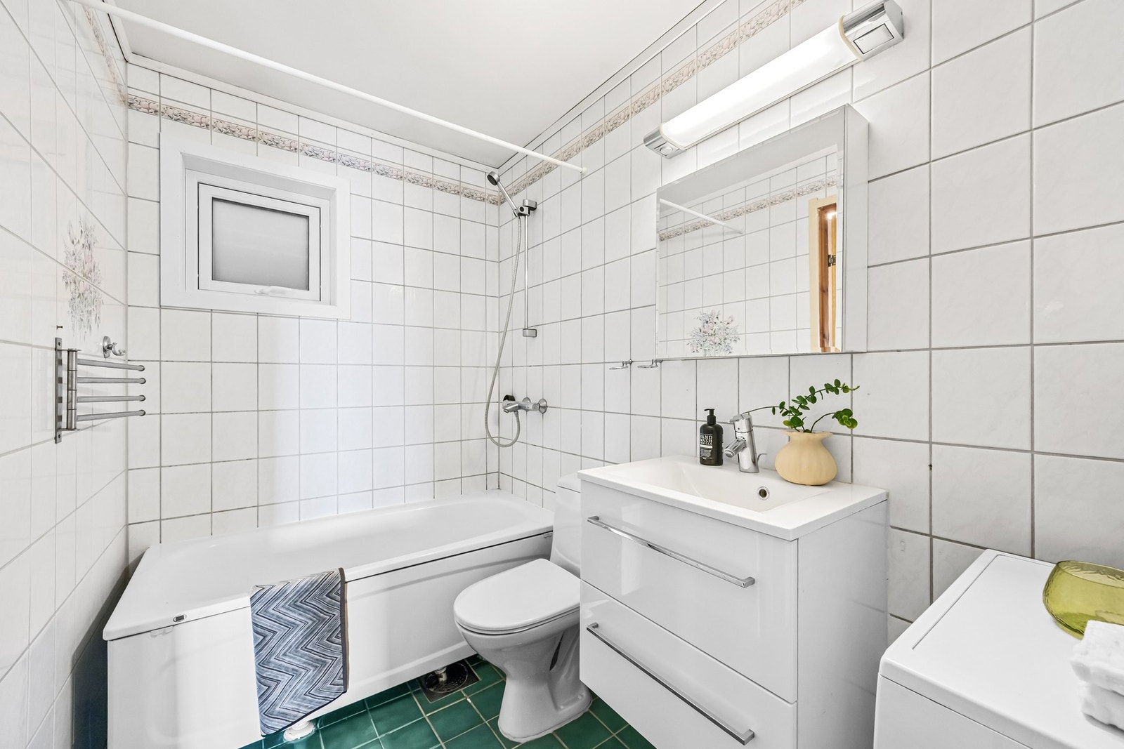 Badet er utstyrt med badekar med dusjløsning samt opplegg for vaskemaskin Galleribilde