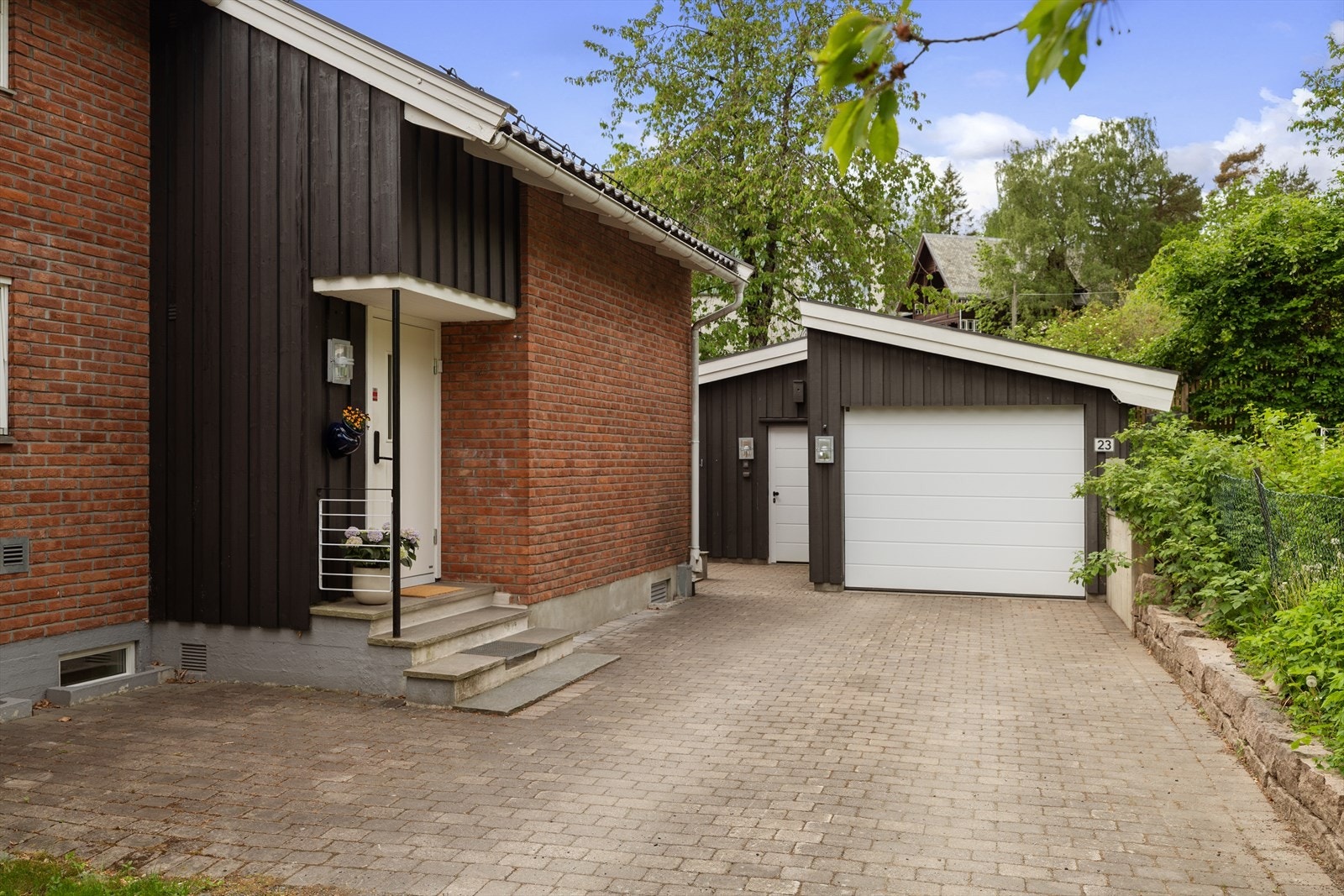 Hyggelig og pent opparbeidet inngangsparti med belegningsstein, biloppstillingsplass og stor frittstående garasje med gode lagringsmuligheter Galleribilde