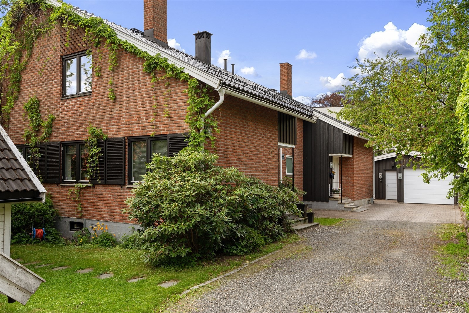 Boligen har en tidløs og vedlikeholdsvennlig teglsteinsfasade. Gårdsplass med stor, frittstående garasje og biloppstillingsplass Galleribilde
