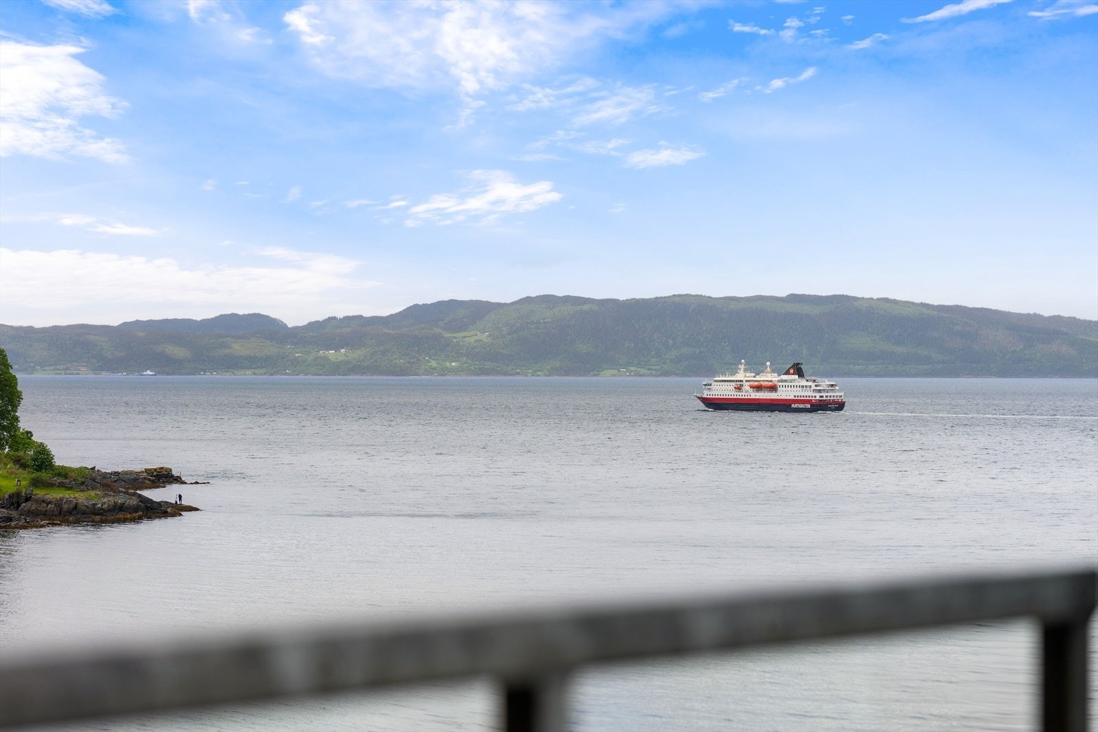 Spektakulær fjordutsikt med hurtigbåten som passerer forbi og vakre Fosenalpene i bakgrunnen. Galleribilde
