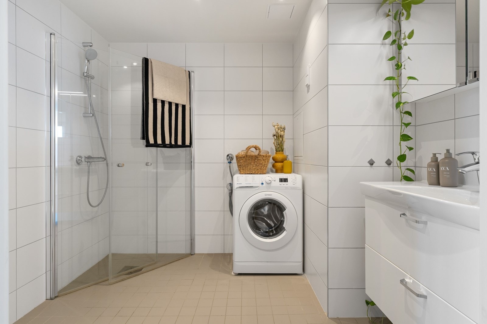 Stilrent, flislagt bad på 5 kvm. Badet har dusj med innfellbare glassdører, servant med underskap, wc, speilskap og opplegg for vaskemaskin. Galleribilde