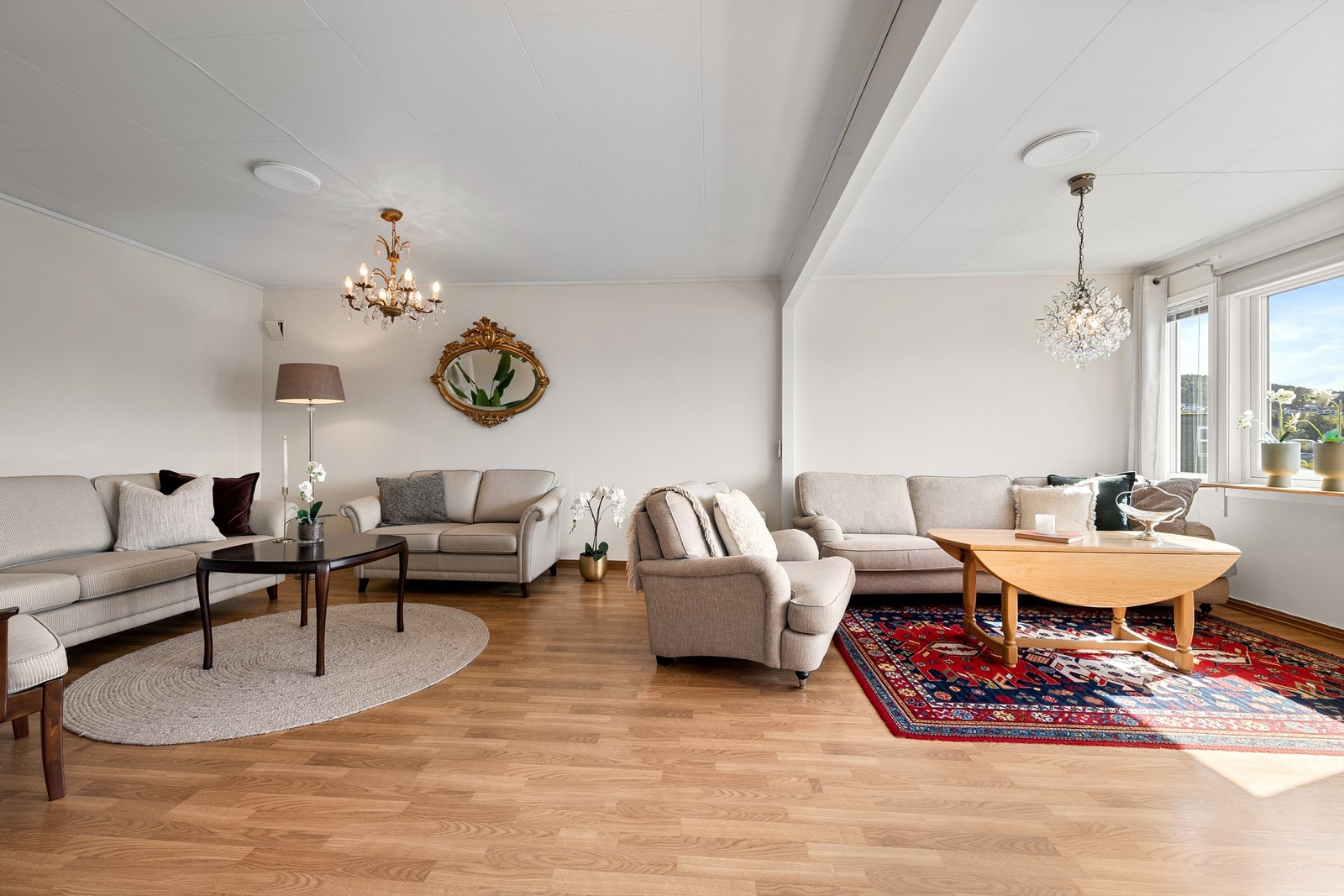 Romslig stue med god plass til flere sittegrupper Galleribilde