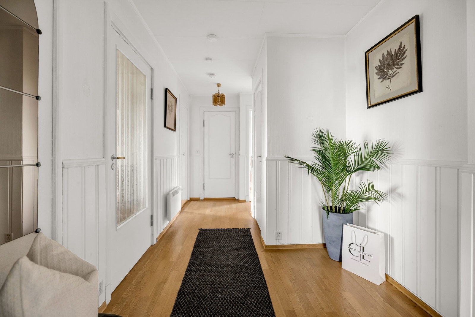 Entréen har lyse vegger, parkettgulv og fine lyslinjer fra de øvrige rommene. Galleribilde