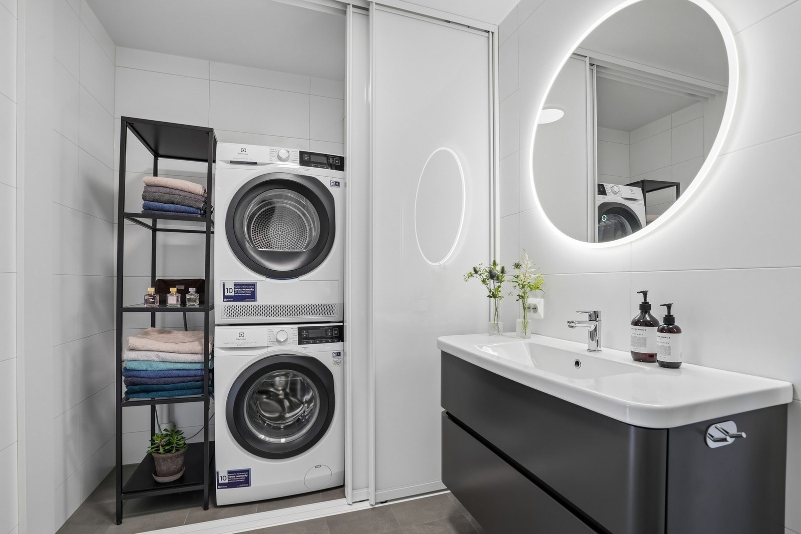 Badet har en smart vaskeromsløsning med vaskemaskin og tørketrommel pent integrert bak skyvedører. Galleribilde