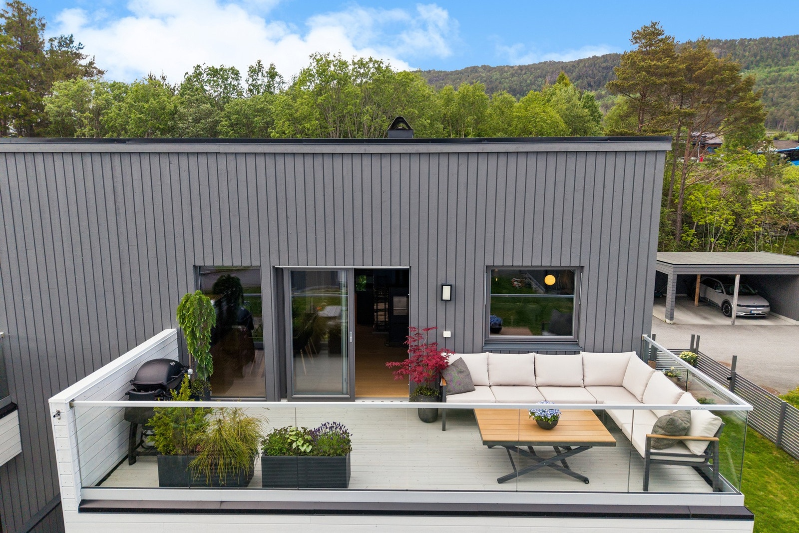 - sydvendt veranda på 16 kvm belagt med spaltegulv av terrassebord og rekkverk av glass. Galleribilde