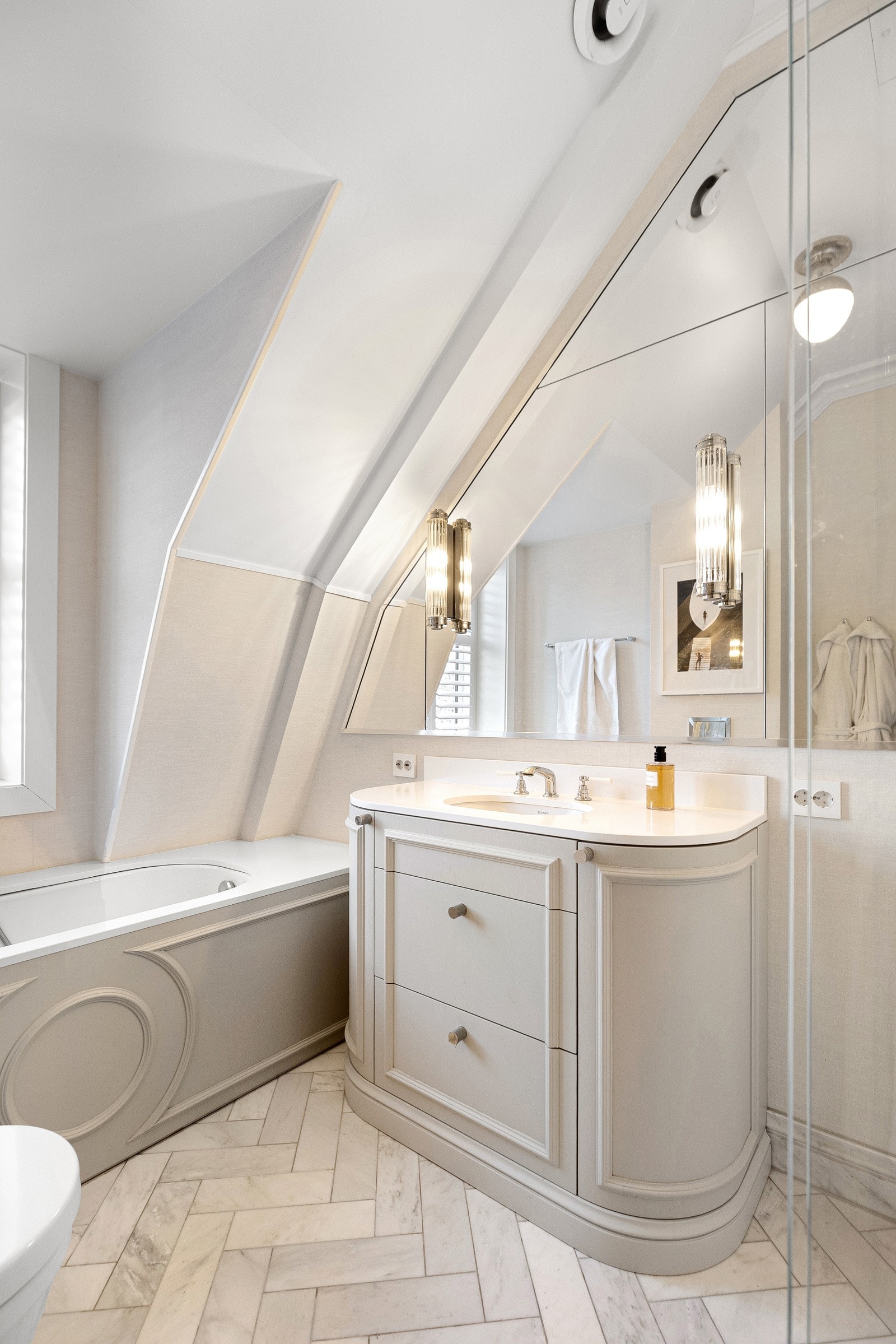 Romslig baderom med badekar, elegant servantinnredning og gjennomført design Galleribilde