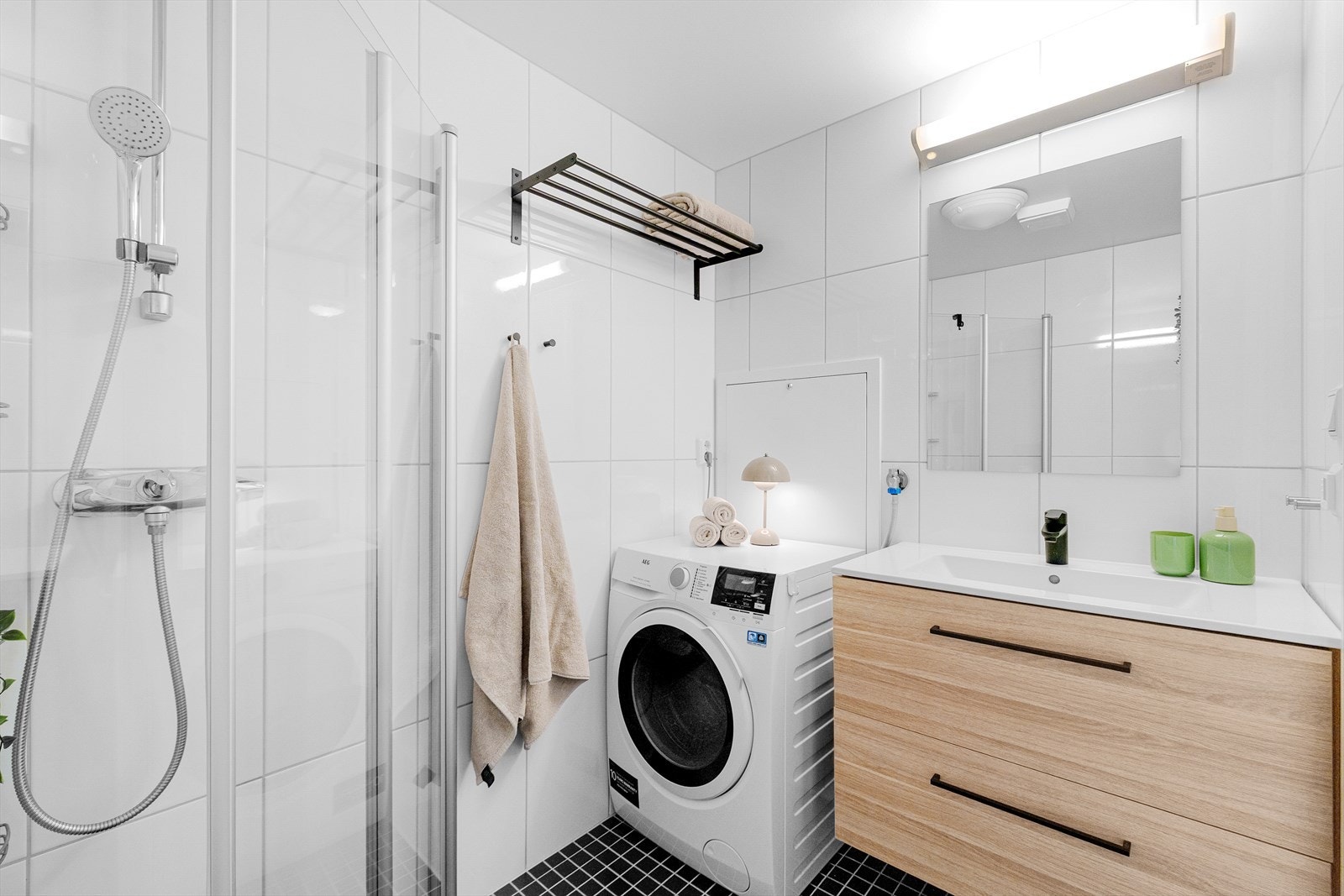 Badet er flislagt med tidløse og slitesterke overflater på både gulv og vegger, kombinert med behagelig elektrisk gulvvarme. Himling med malte plater gir et lyst og rent uttrykk. Servant og servantskap er nytt fra 2024. Galleribilde
