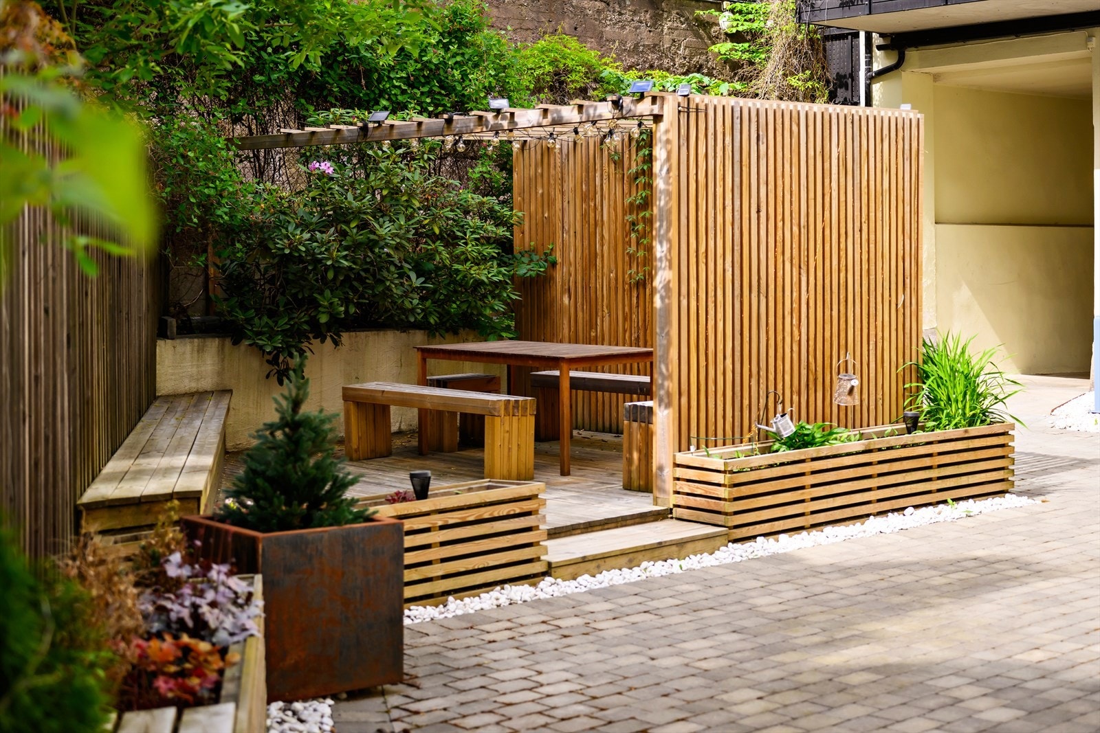 Pent opparbeidede fellesareal med sittegruppe og beplantning. Galleribilde
