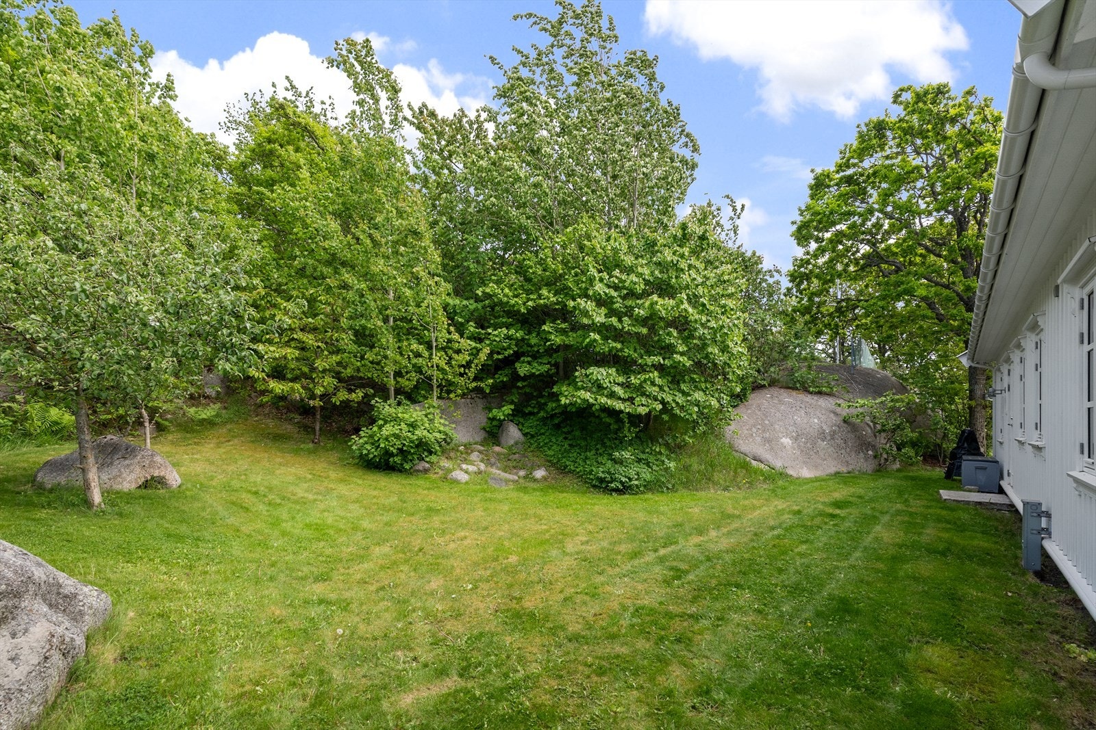 Tomten består av plen og naturtomt med svaberg. Galleribilde