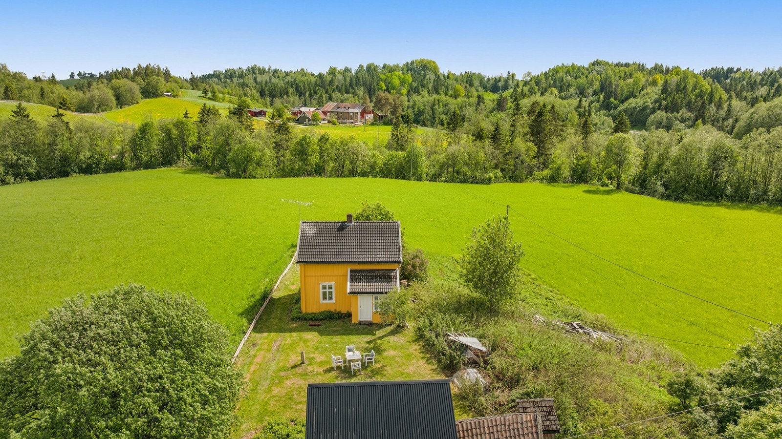 Solrik eiendommen omgitt av jorder. Galleribilde