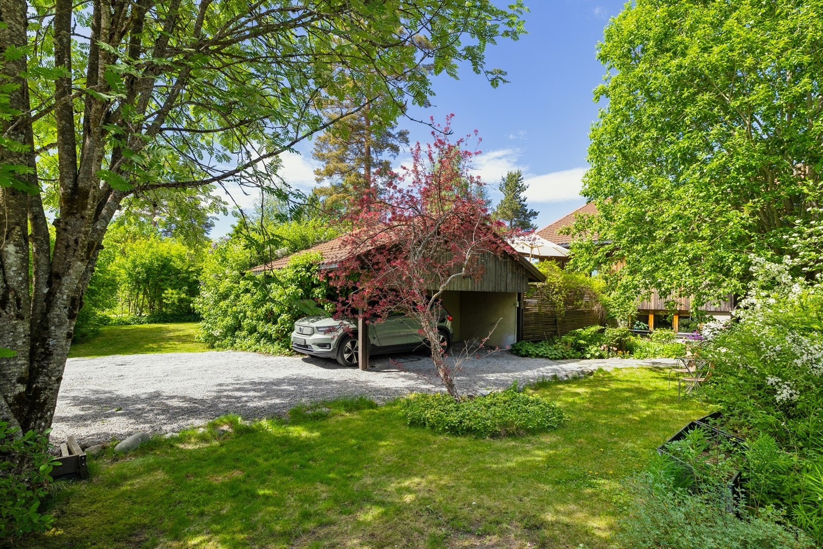 I tillegg til carport er det god plass til flere biler på tomten Galleribilde
