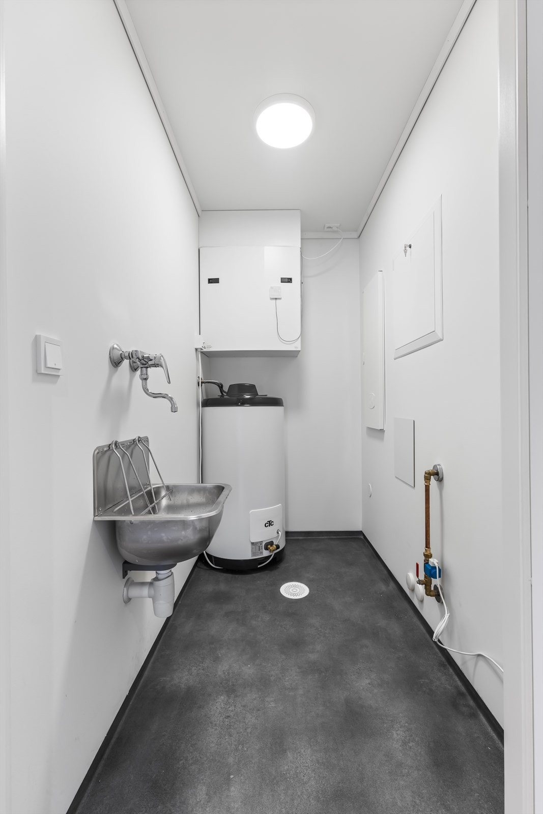 Praktisk teknisk rom med opplegg for vaskemaskin og plass til oppbevaring. Galleribilde