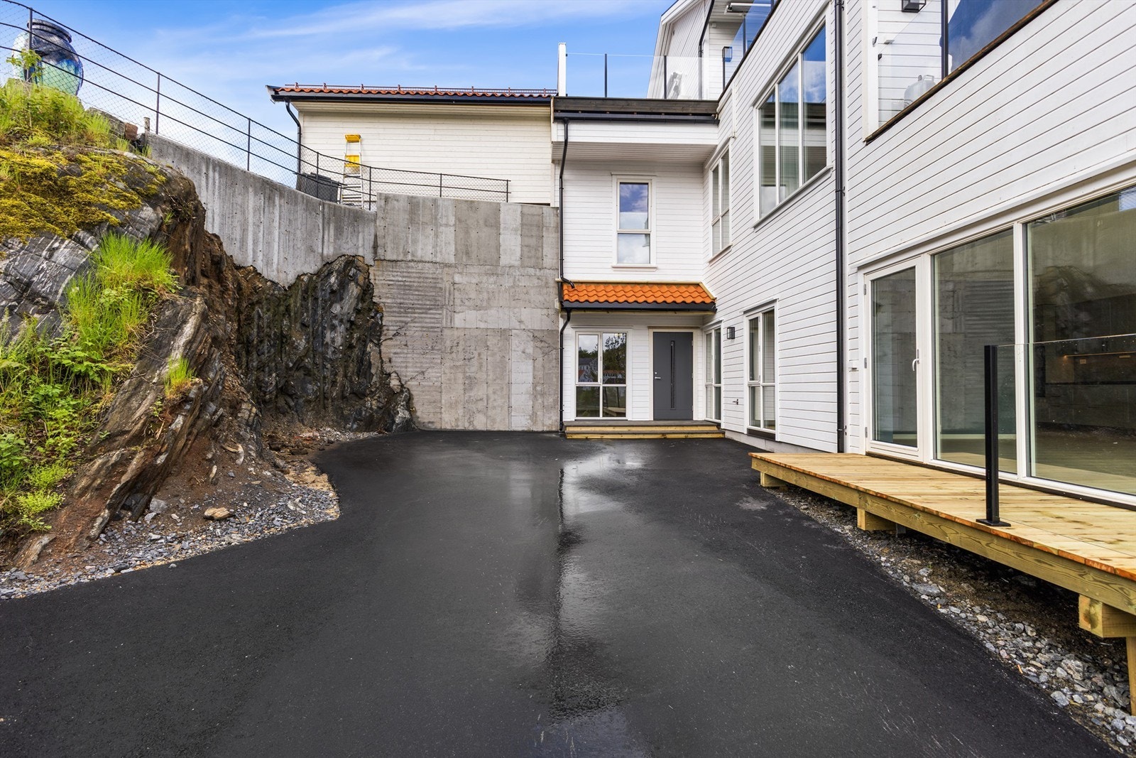 Asfaltert og lettstelt uteområde ved inngangspartiet. Galleribilde