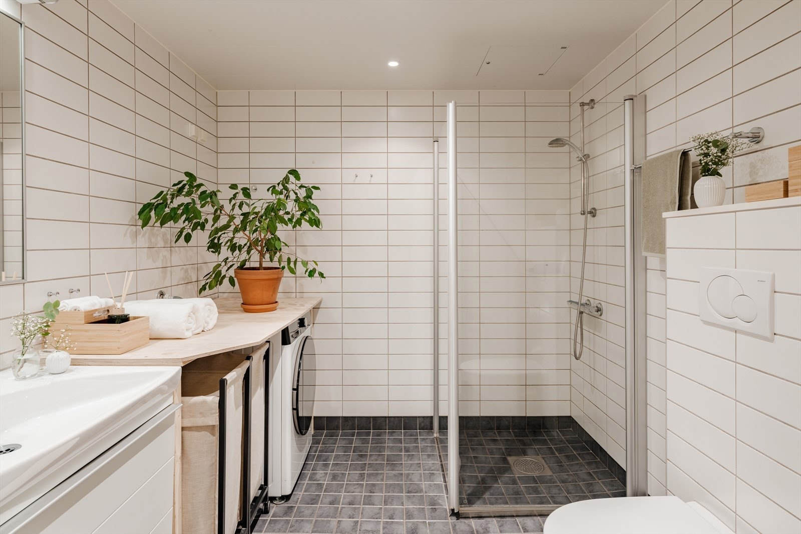 Fra entreen er det tilgang til baderommet. Badet har lyse, tidsriktige fliser på vegger og grå fliser på gulv. Galleribilde