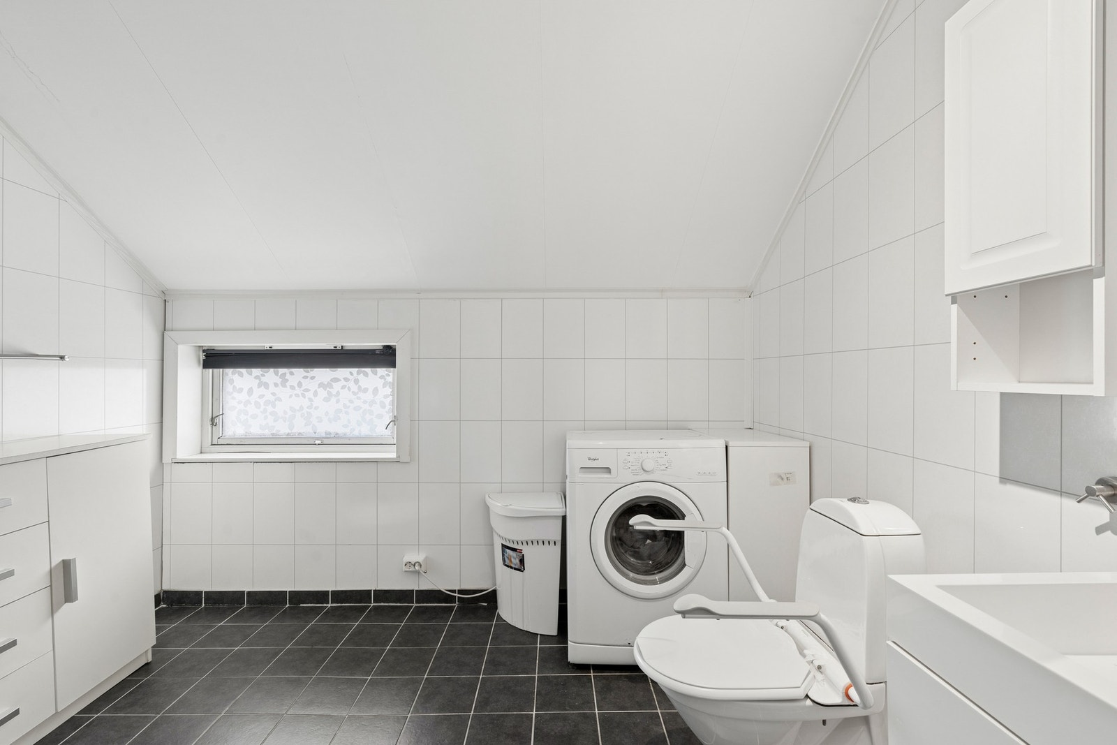 Rommet er utstyrt med dusjkabinett, servantmøbel, toalett og har opplegg for vaskemaskin. Galleribilde