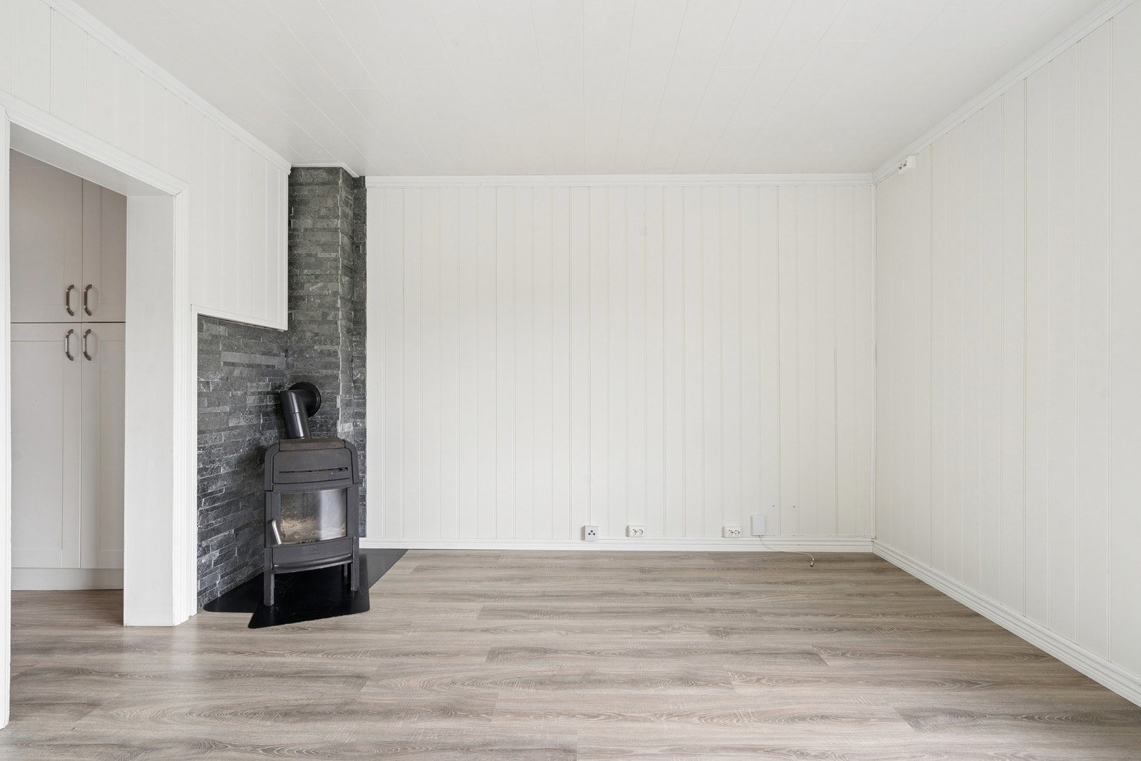 En lukket vedovn ved mursteinspipen gir effektiv og behagelig varme. Galleribilde