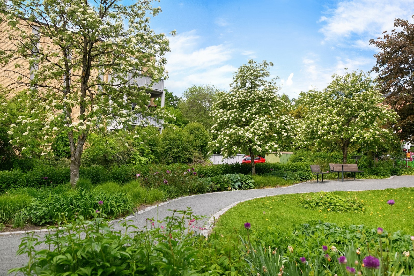 Benkow parken i nærheten, med pent anlagte grøntsoner med vakre trær, plen og diverse beplantning. Galleribilde