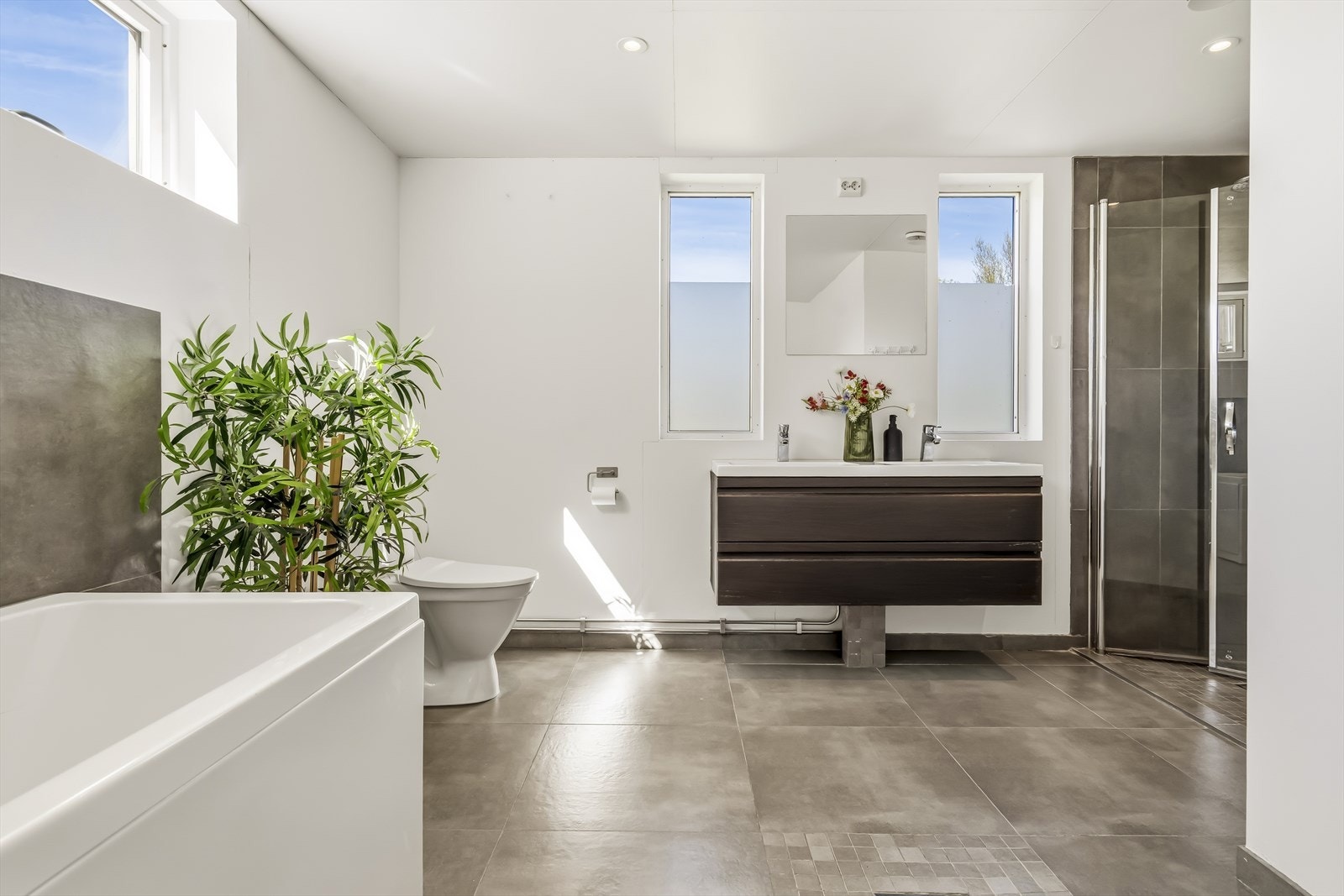 Badet har malte plater på veggene og flislagt gulv. Galleribilde