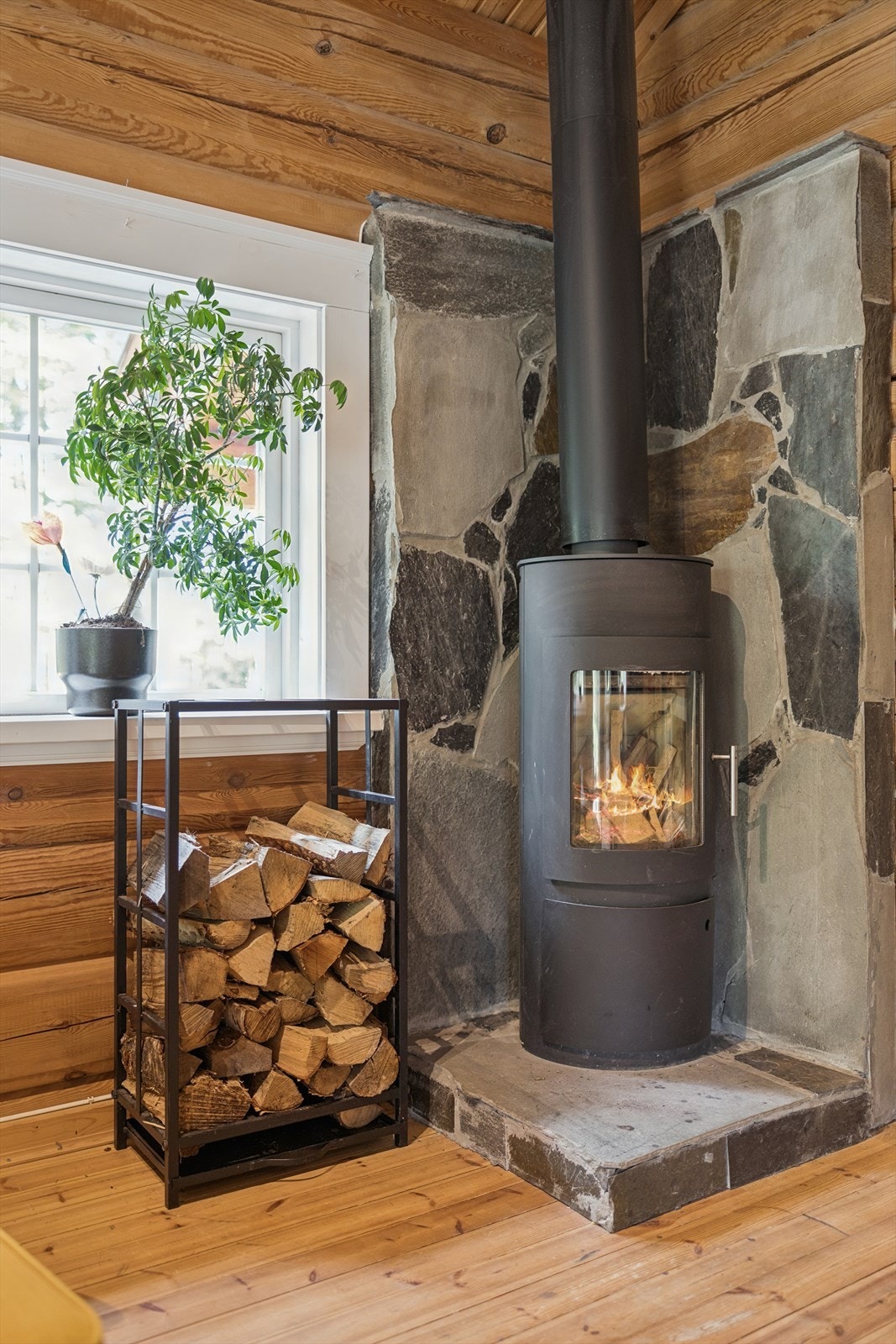 Den lukkede peisovnen med toppmontert stålpipe gir effektiv varme og hygge på kjølige dager. Galleribilde