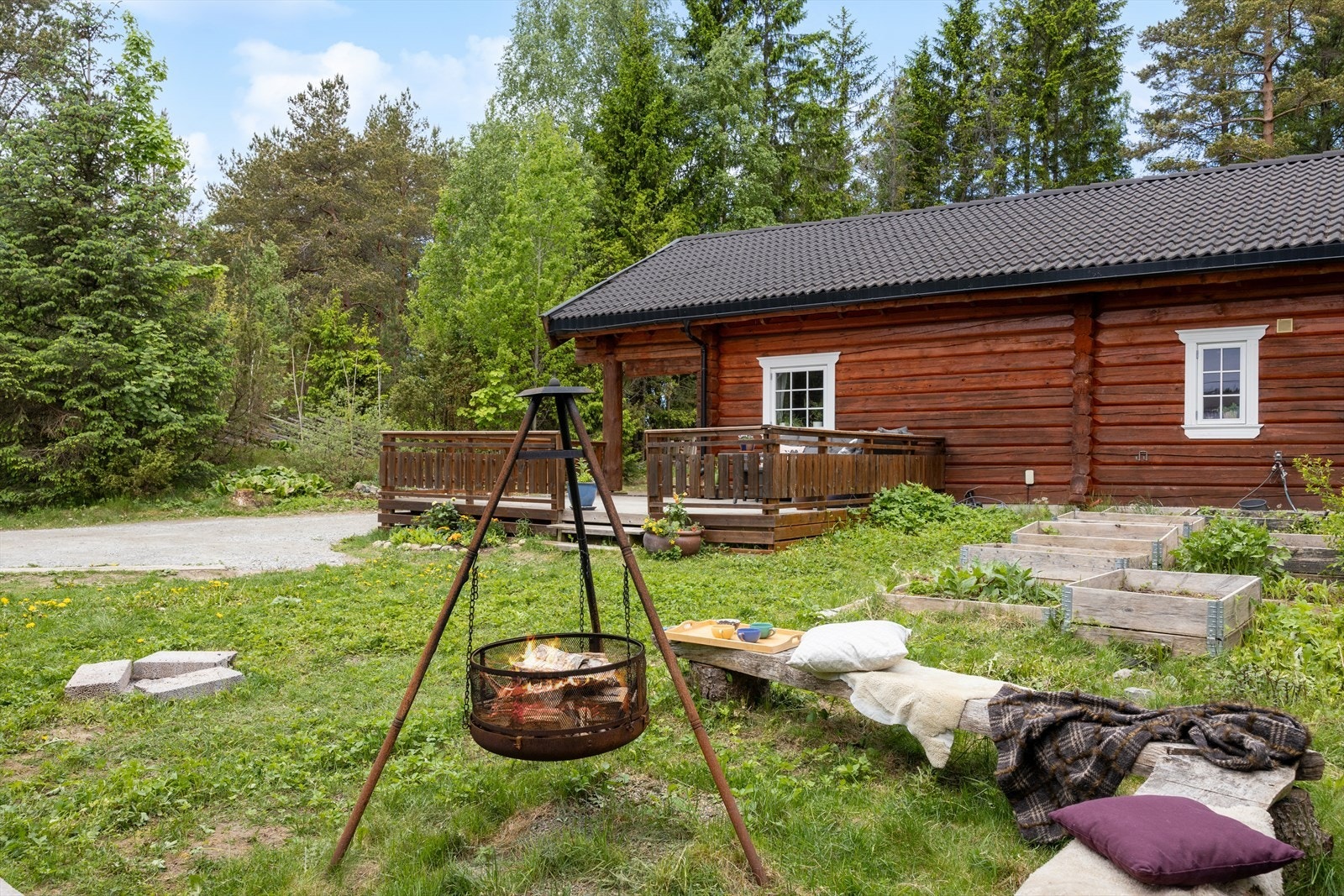 Tomten er en blanding av naturtomt og opparbeidet hage med gressplen og gruset innkjørsel. Galleribilde