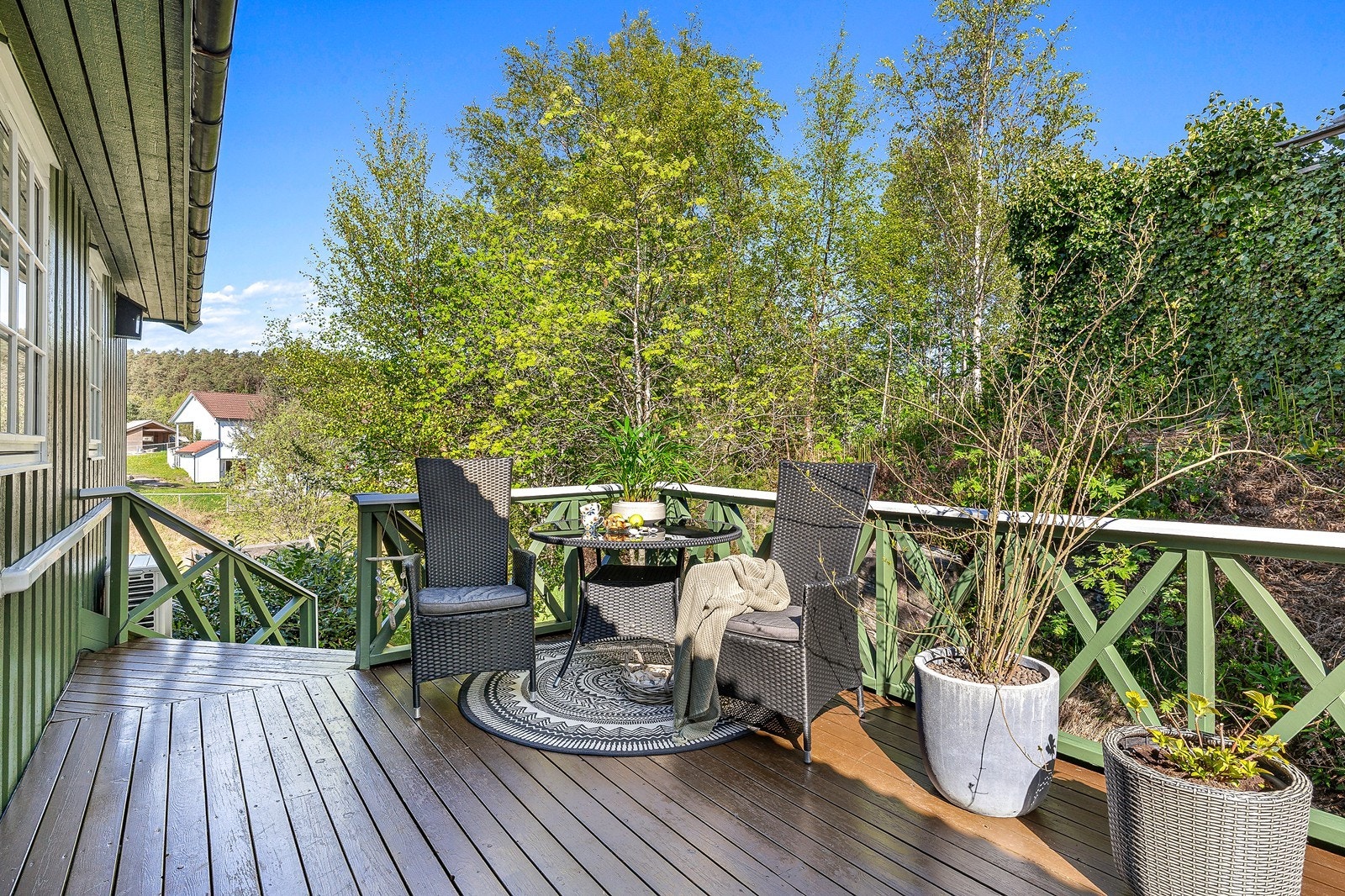 Det er bygget terrasse rundt deler av bolig med tilkomst fra stue, vaskerom og bakkeplan. Galleribilde