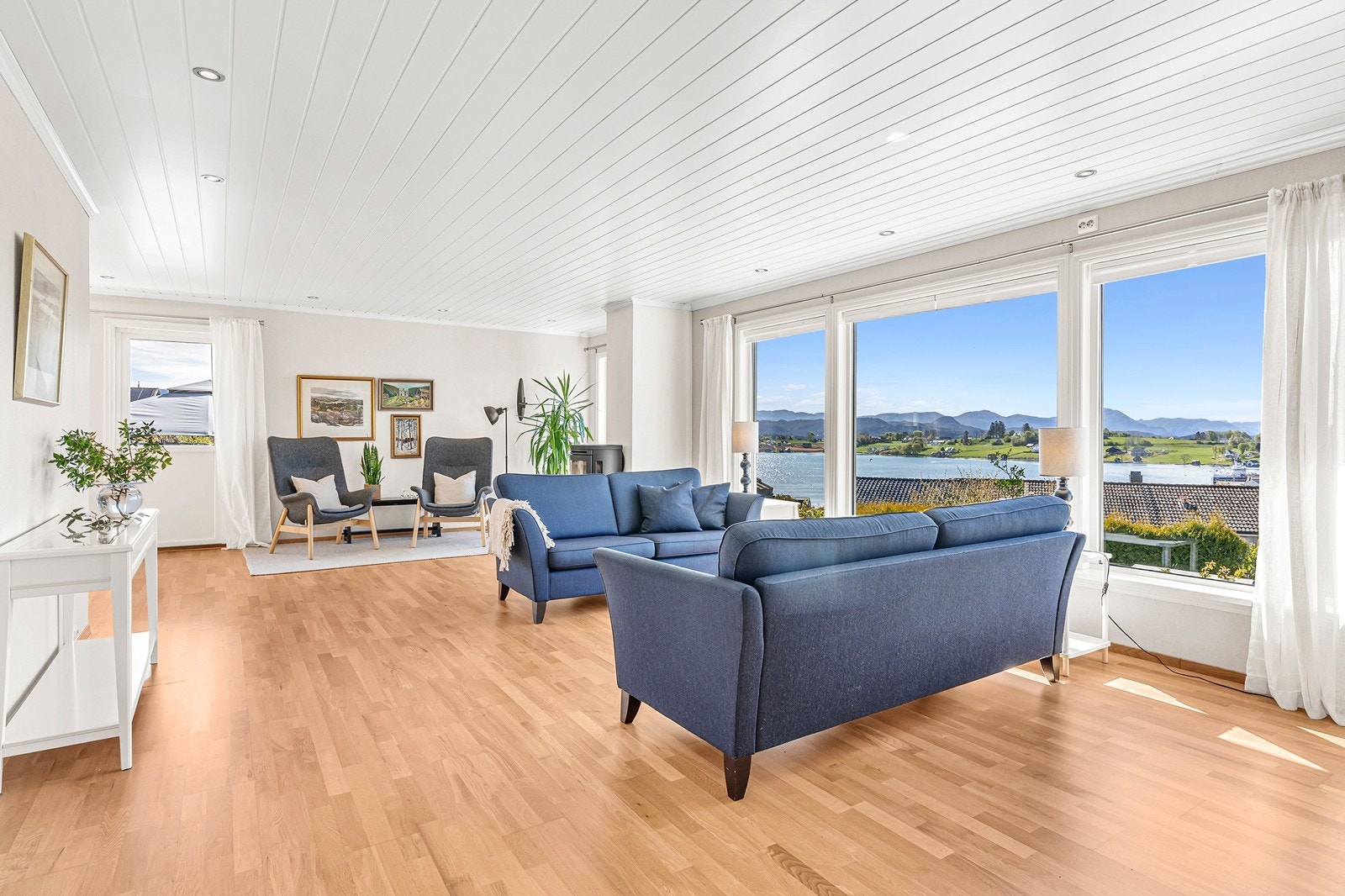 En lys og fin stue med parkett på gulv og lysmalte vegger Galleribilde