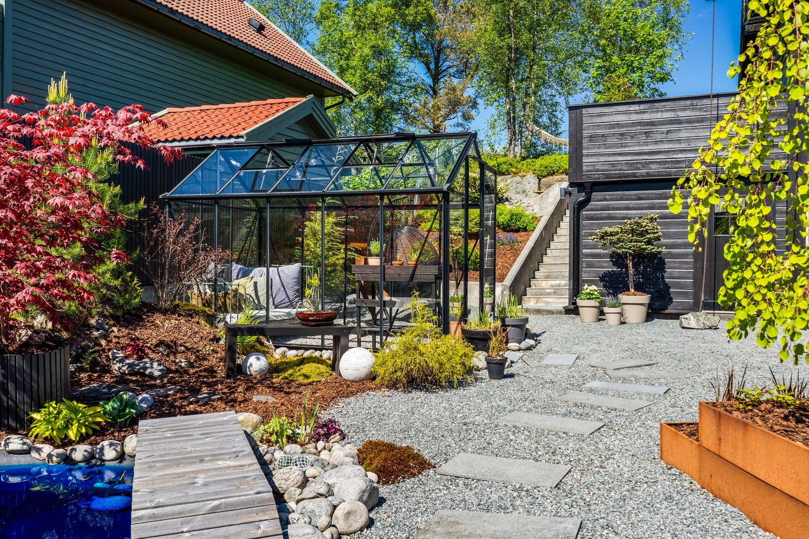 Det er opparbeidet en større Japansk-inspirert sone med ulike grønne vekster, flere stier, pergola, hagedam og et drivhus. Galleribilde