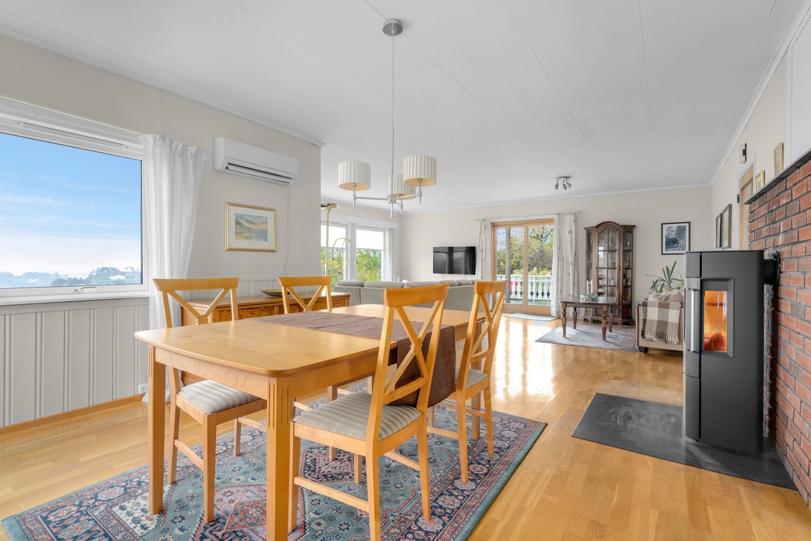 Det er god plass til langbord i spisestuedelen. Peisovnen skaper en koselig atmosfære med store glassflater. Galleribilde