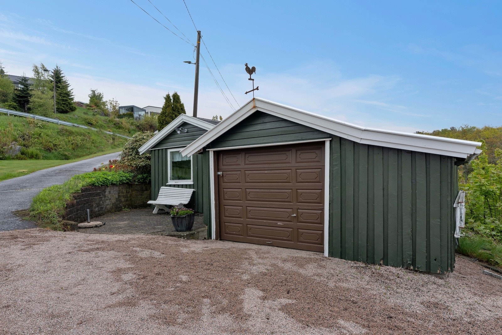 På gårdsplassen er det en frittstående garasje og et uthus/verksted. Galleribilde
