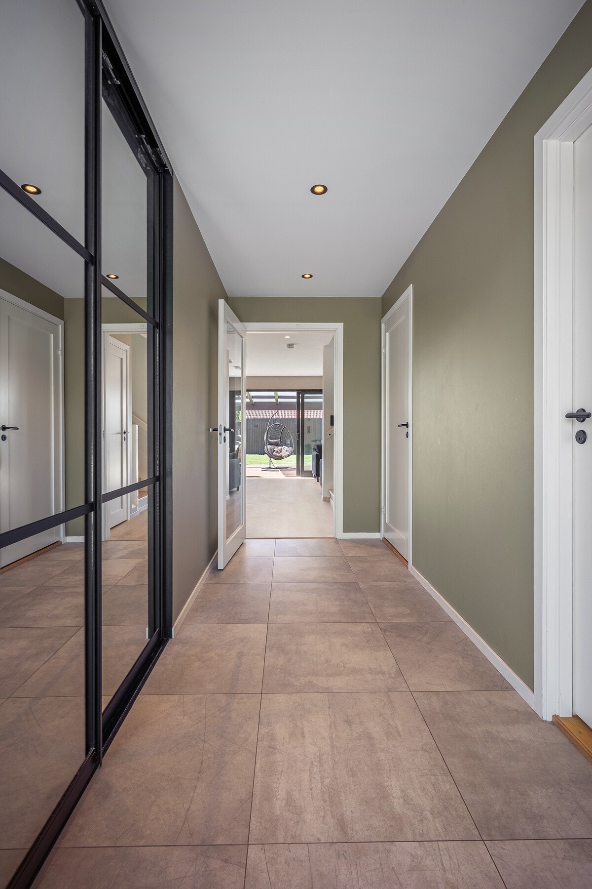 Boligen ønskes velkommen via et overbygd inngangsparti som leder inn til en lys og innbydende entré. Her er det god plass til oppbevaring av yttertøy og sko i en stor og praktisk skyvedørsgarderobe med speilfronter. Entréen har flislagt gulv med gulvvarme Galleribilde