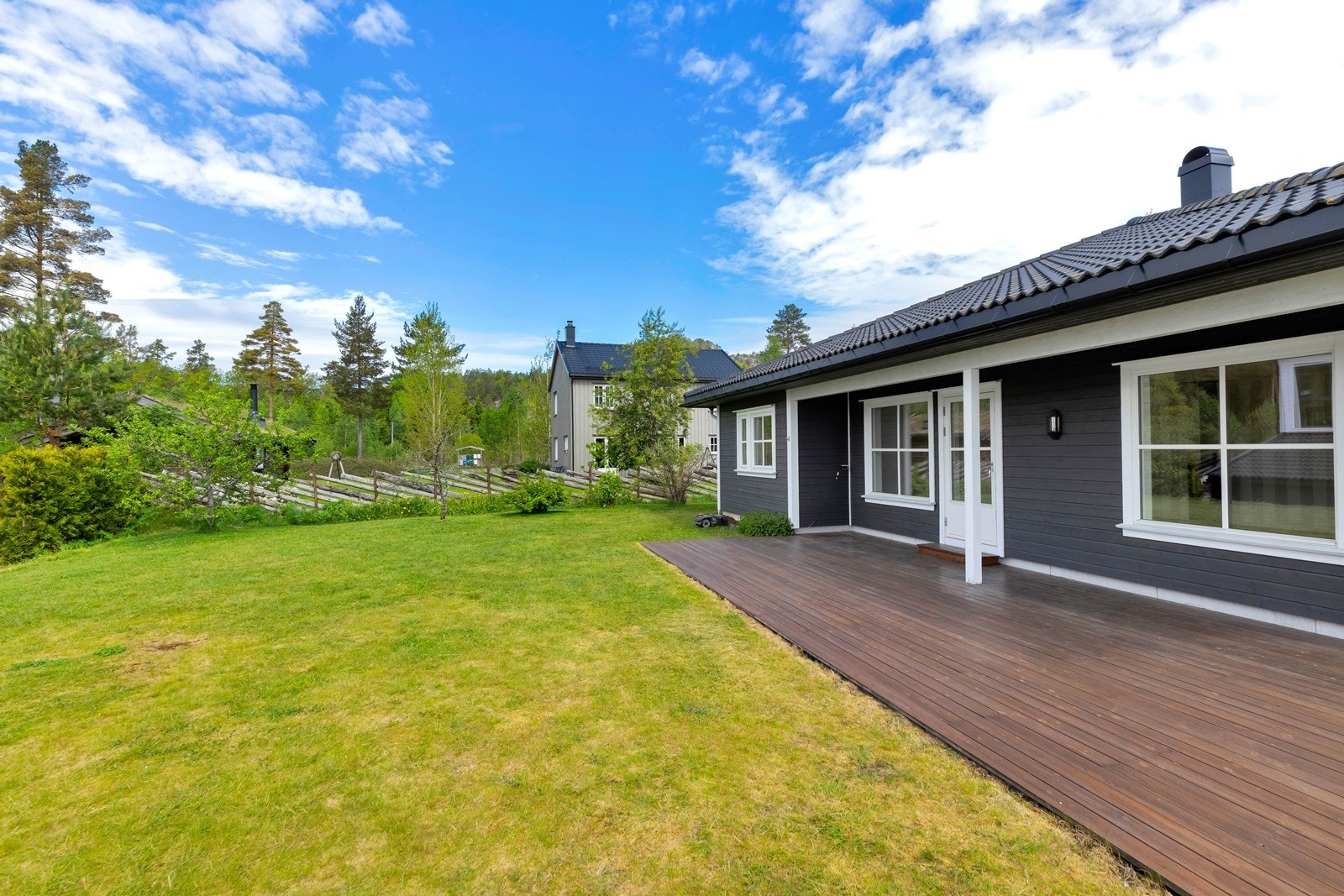 Pent opparbeidet tomt med plen og noe beplatning. Galleribilde
