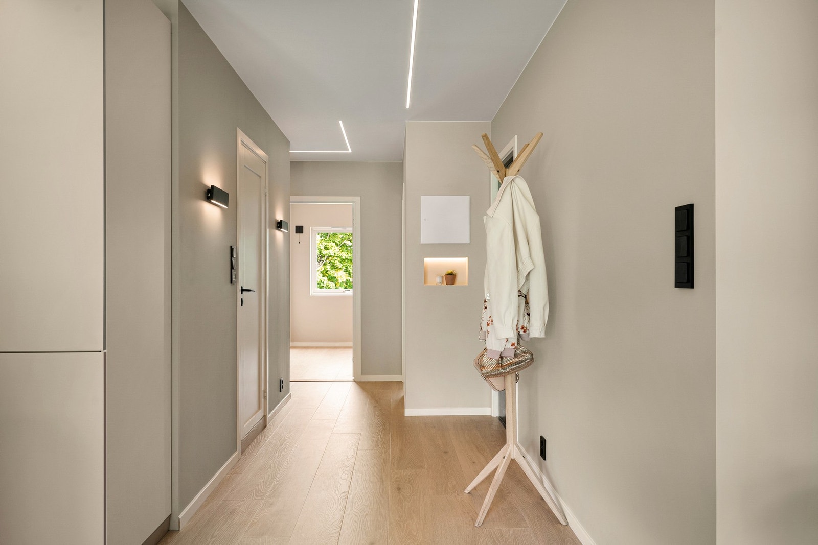Lys og romslig entrè med moderne ledskinner i tak - og pene vegglamper. Galleribilde