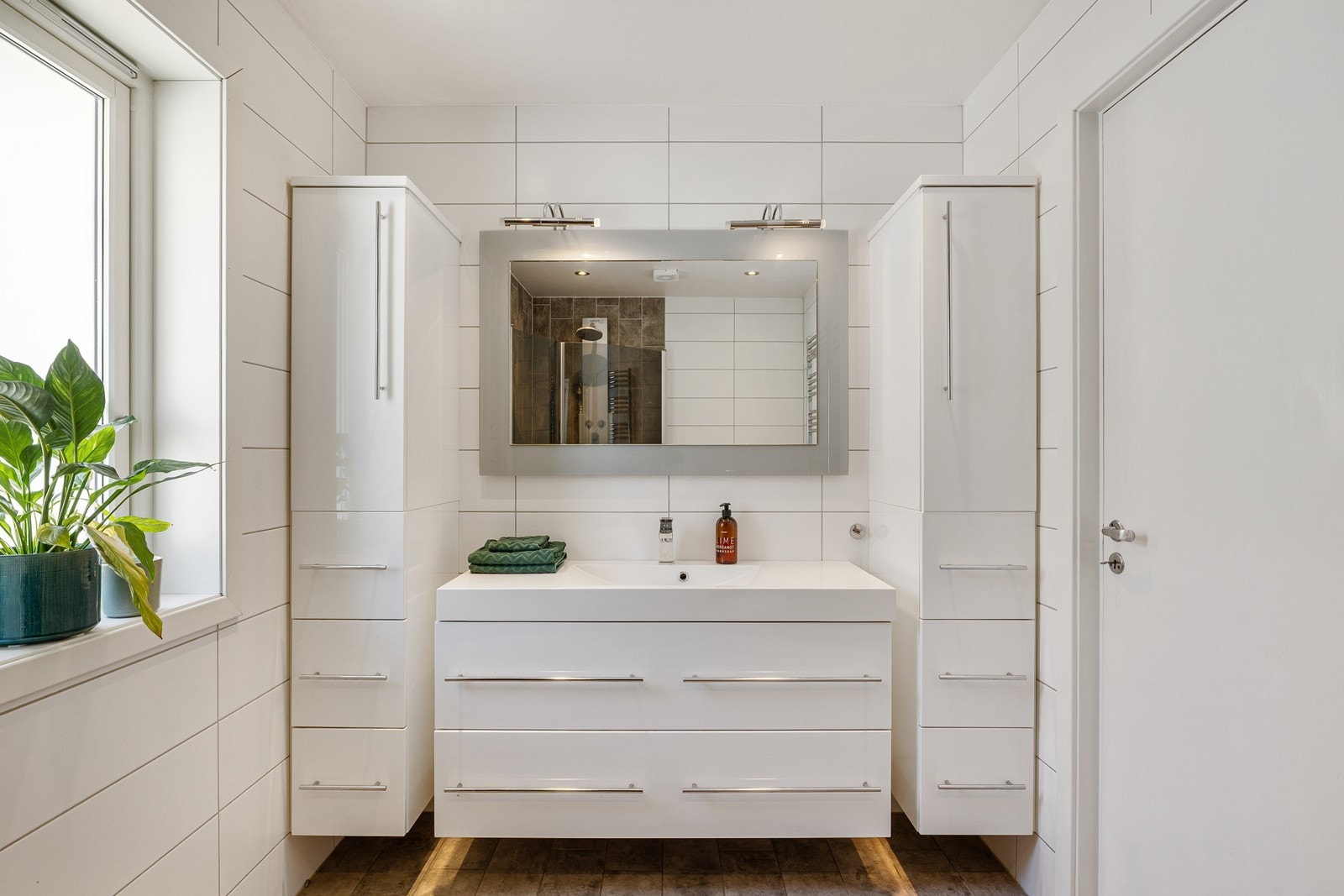 Badet er innredet med servant, underskap, sideskap, speil og et vannklosett. Galleribilde