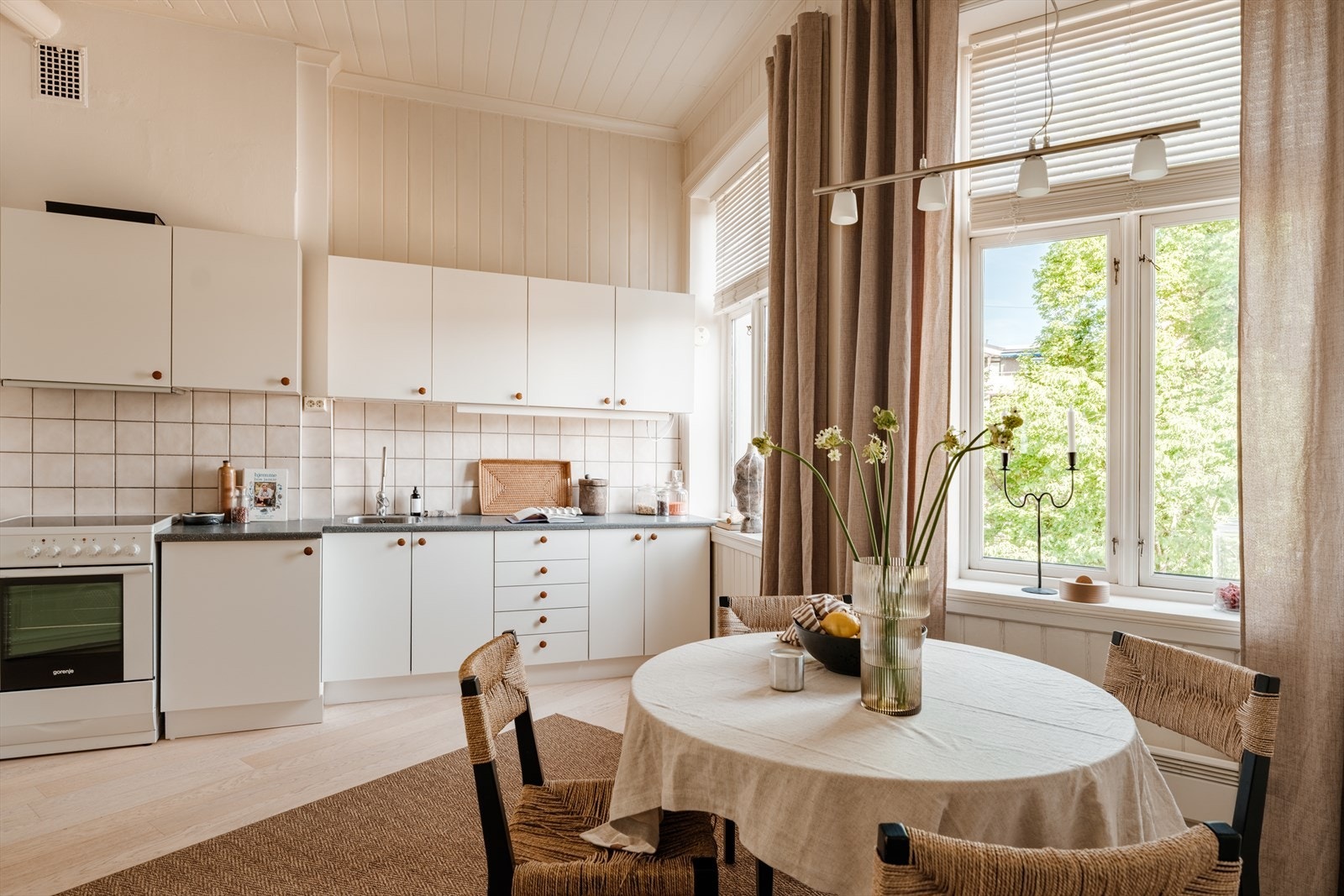 Enkel innredning med slette fronter, fliser og belysning over laminat benkeplate med oppvaskkum og blandebatteri. Det er avtrekksvifte med kullfilter. Galleribilde