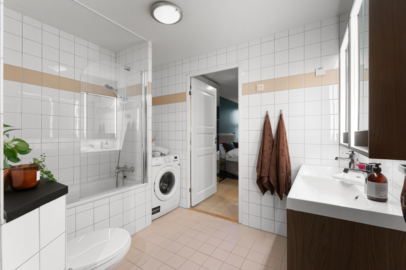Badet er flislagt med varmekabler og har en praktisk utforming med god plass til både vaskemaskin og tørketrommel. Galleribilde