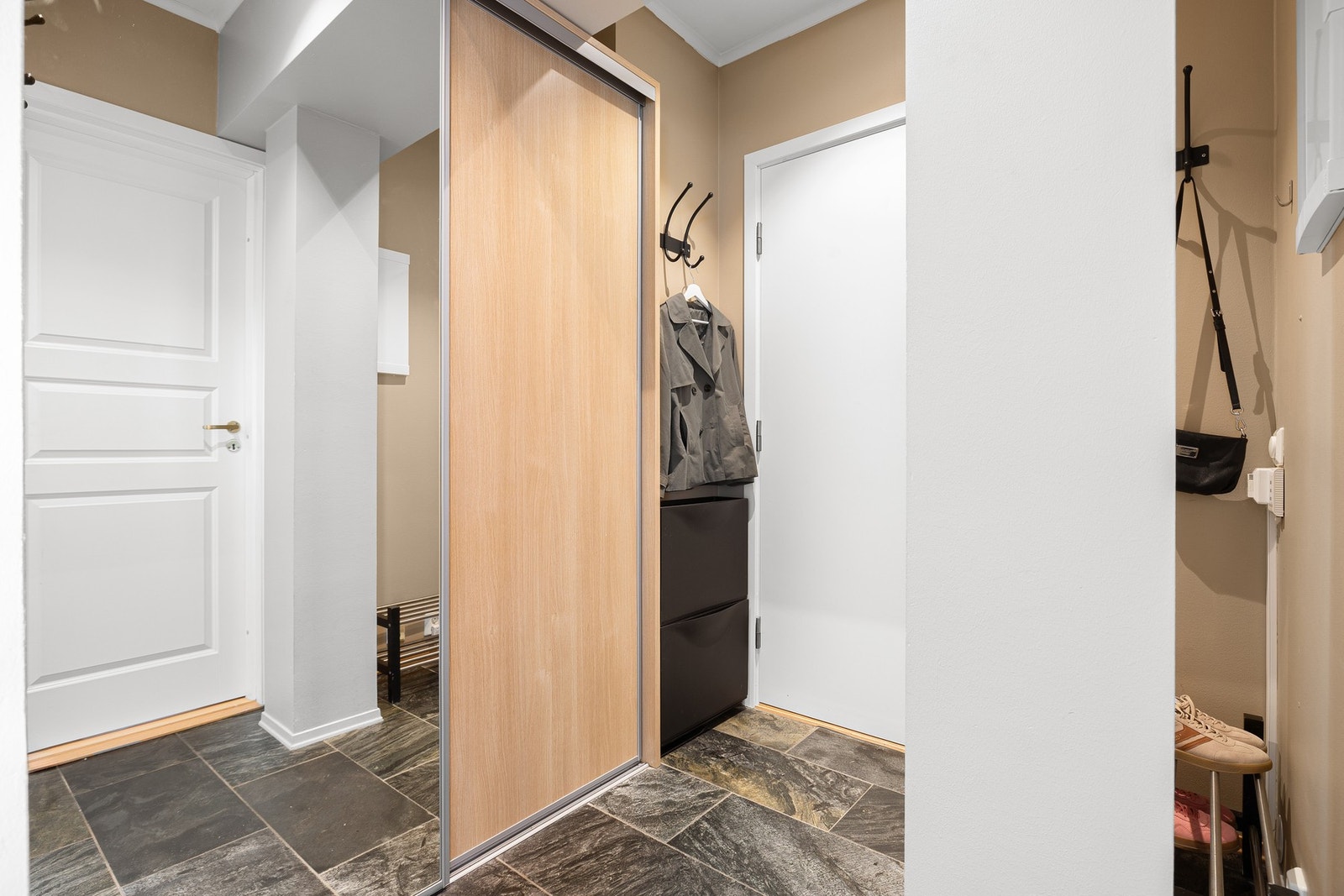 Velkommen inn! Entréen måler 4,1 kvm og har en praktisk og stilfull skyvedørsgarderobe, som gir utvidede muligheter for oppheng av yttertøy og oppbevaring av sko. Galleribilde