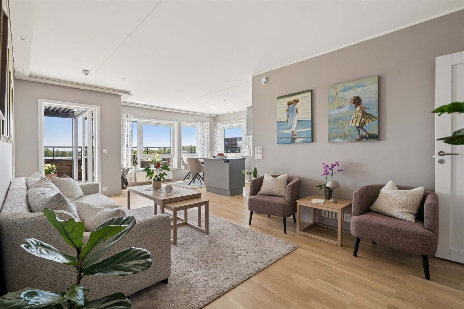Den lyse stuen med åpen løsning til kjøkkenet har stor vindusflate og utgang til terrasse Galleribilde