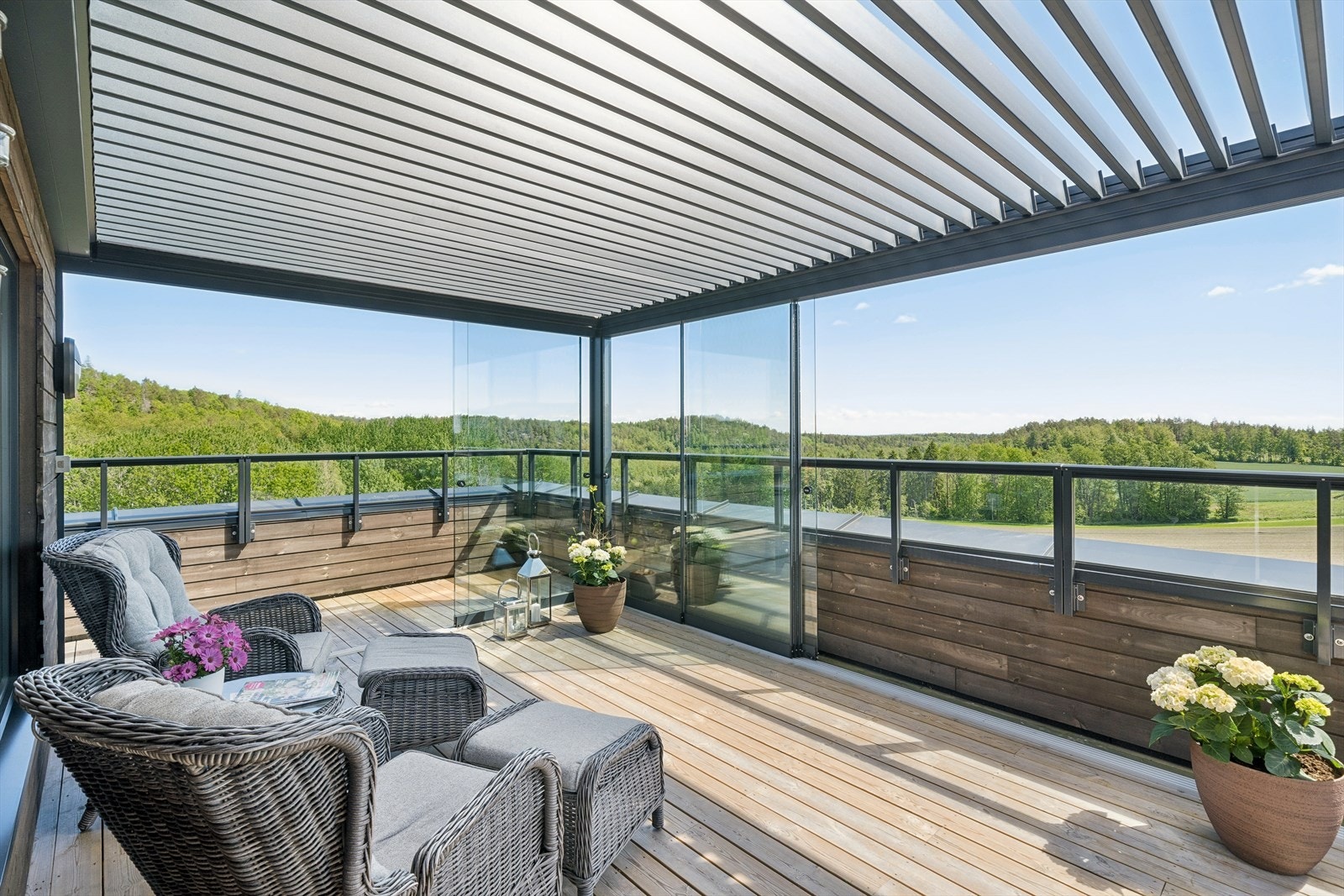 Innglasset pergola- Du kan skyve glass og tak til side, eller sitte helt i lé for vær og vind Galleribilde