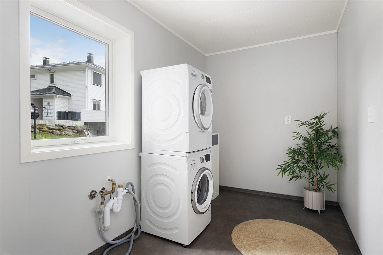 Funksjonellt vaskerom med opplegg til vaskemaskin. Badet er av god størrelse med rom for oppbevaring, og plass til tørkestativ. Galleribilde