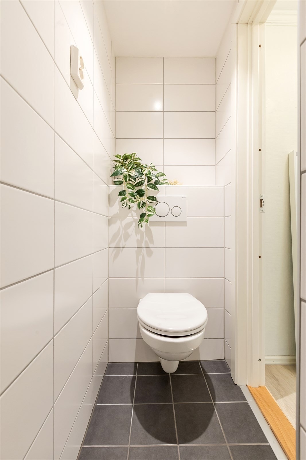 Rommet er utstyrt med veggmontert toalett, dusjplass med dusjvegger og baderomsinnredning med skuffer, servant med ettgrepsbatteri og belysning. Galleribilde
