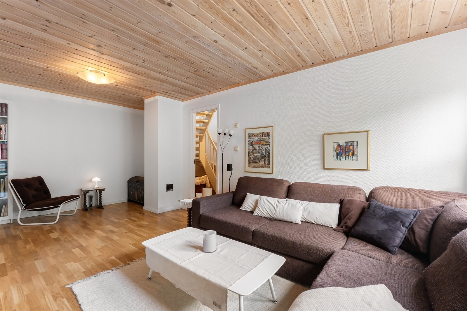Rommet har panel i himlingen og parkett på gulvet, og trappeforbindelse opp til første etasje. Galleribilde