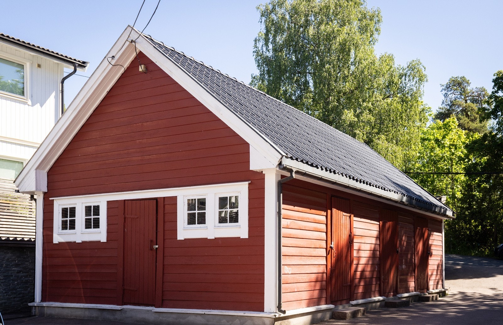 Bodarealene til boligen er i det røde huset bak villaen. Galleribilde