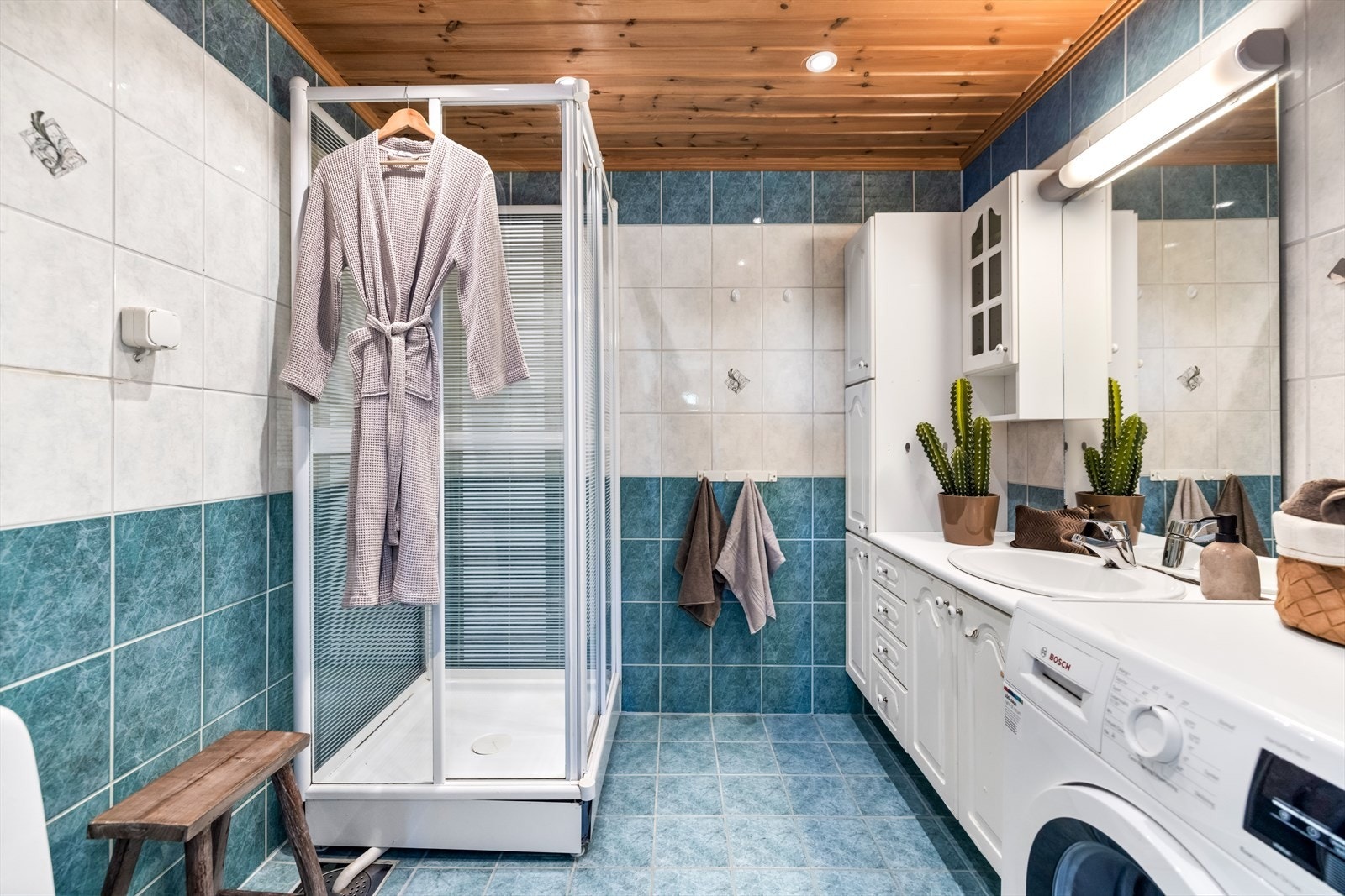 Badet har flislagte vegger, flislagt gulv med varmekabler og panel i taket. Galleribilde