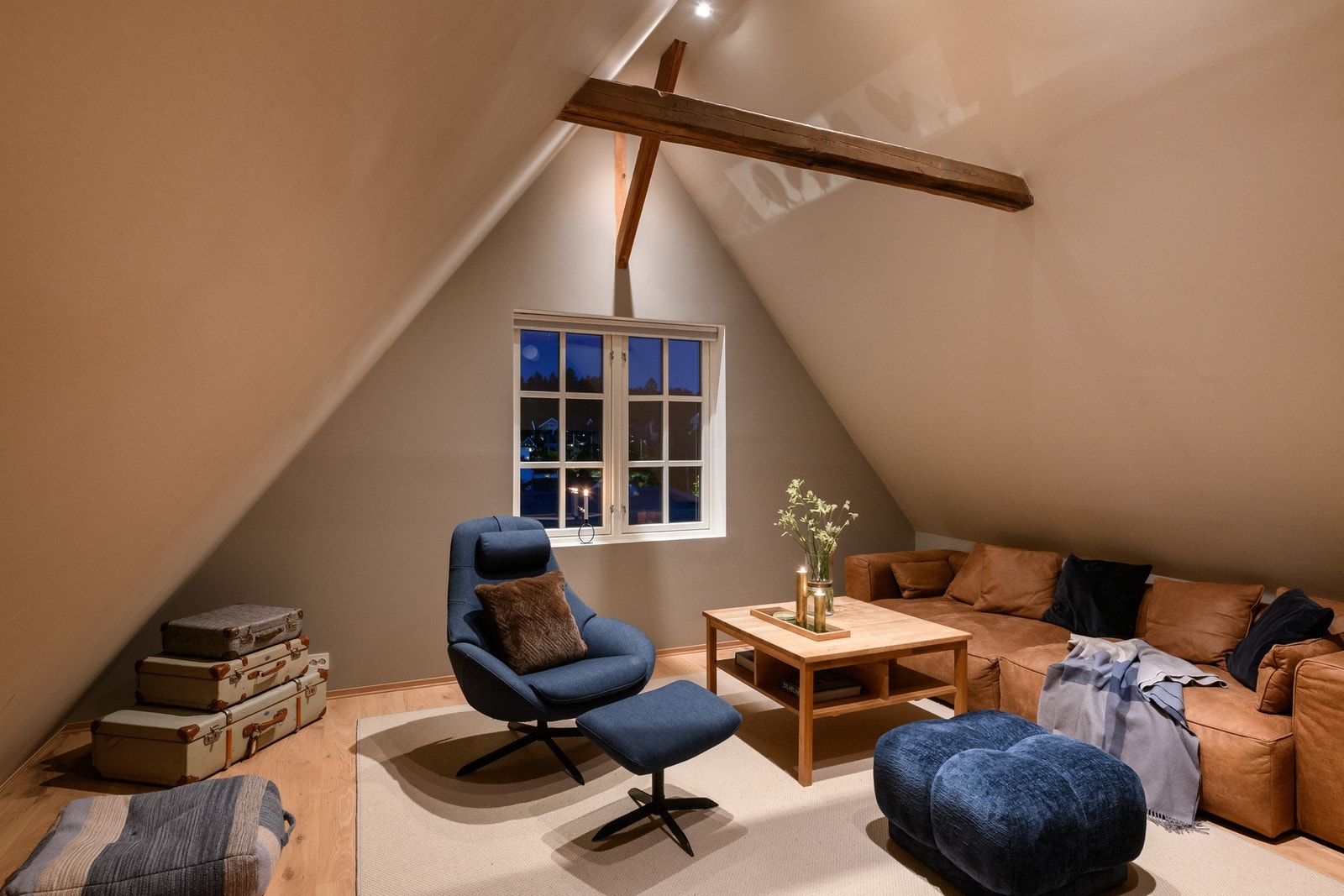 Loftstuen har en takhøyde på 3,42 meter under mønet, med synlige takbjelker. Galleribilde